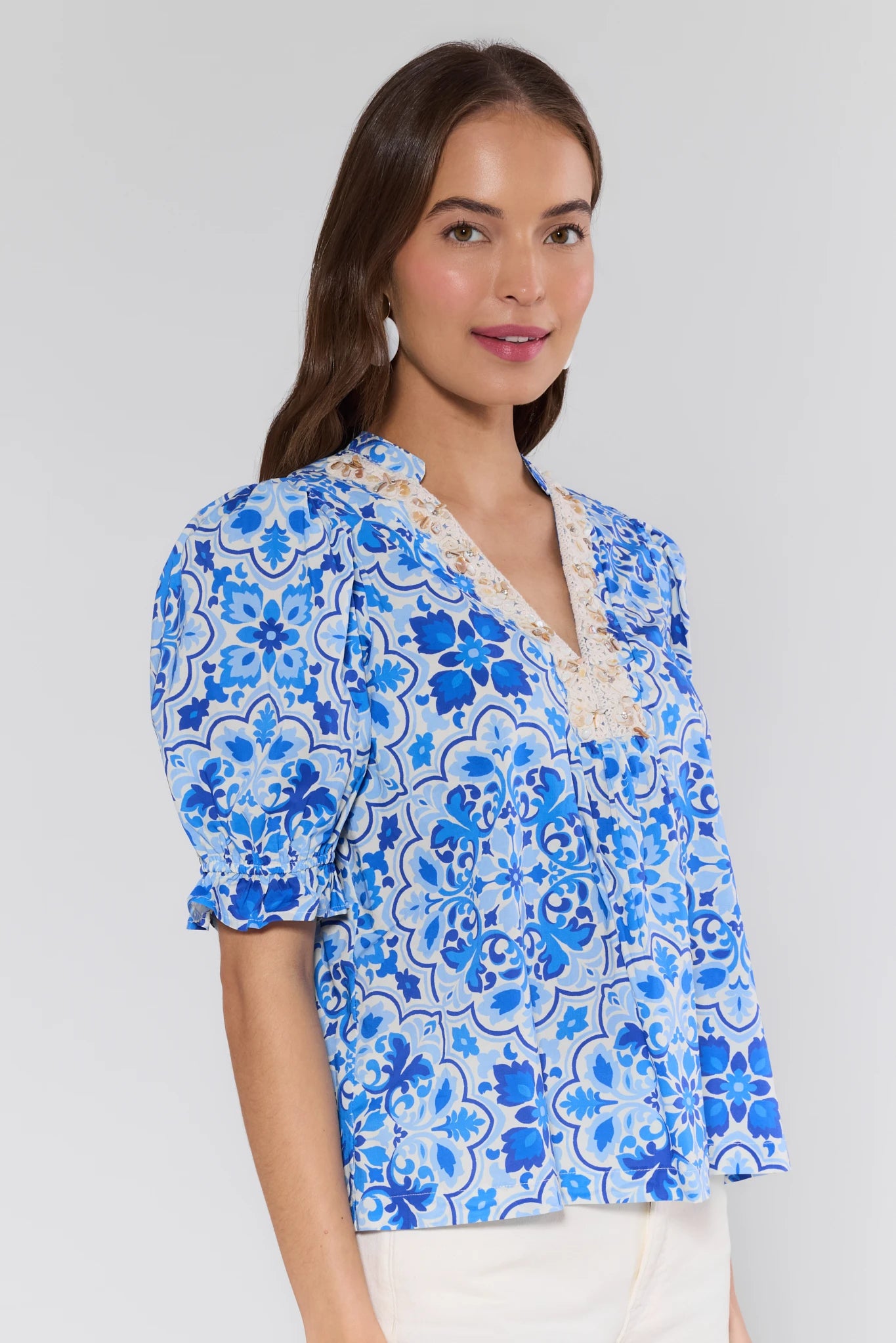 Woman wearing a blue floral blouse with a white background