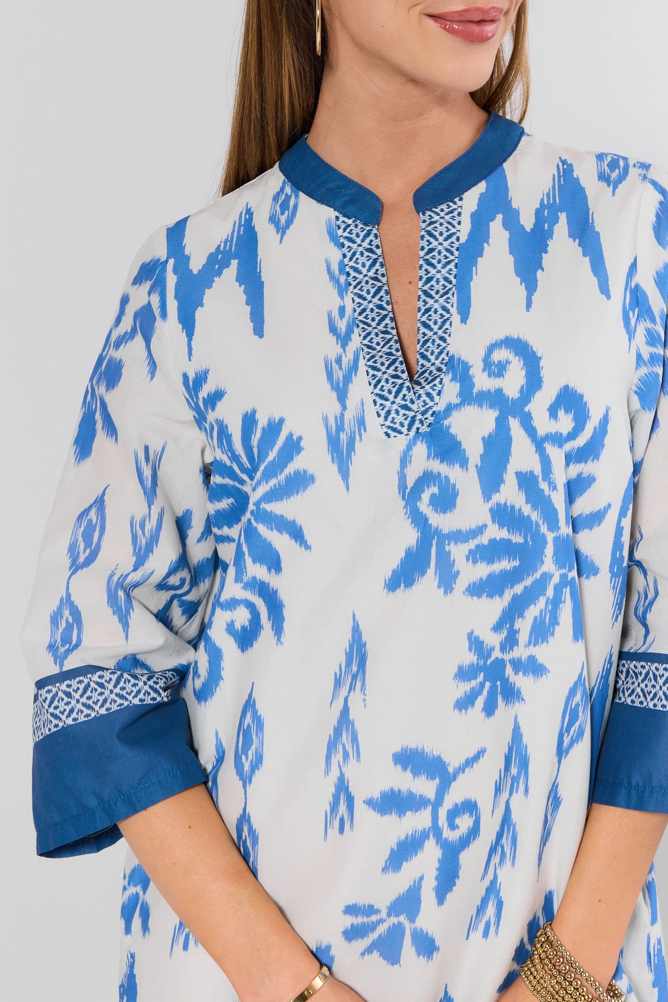 Woman wearing a blue and white patterned dress with a plain background