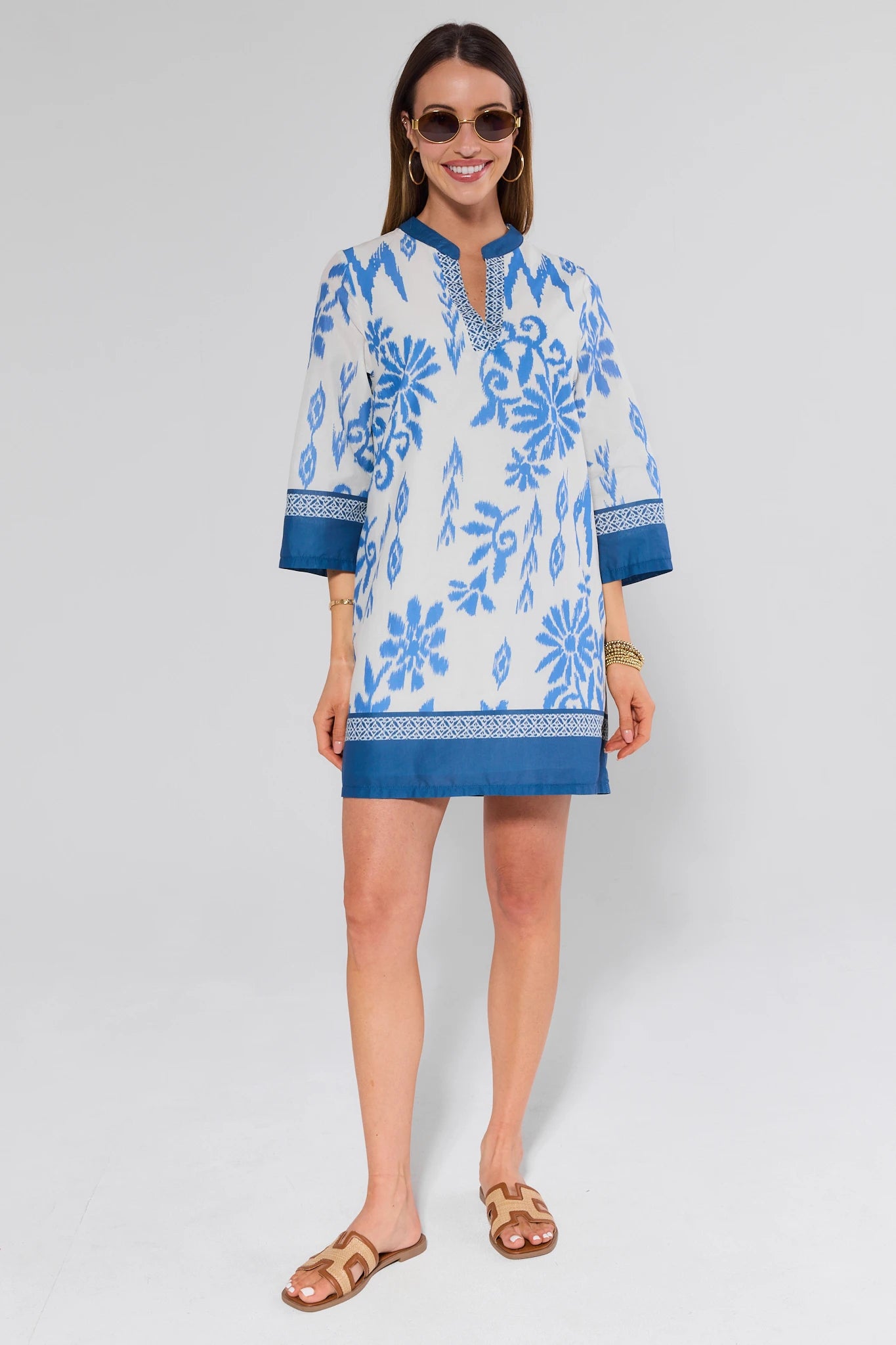 Woman wearing a blue and white floral dress on a white background