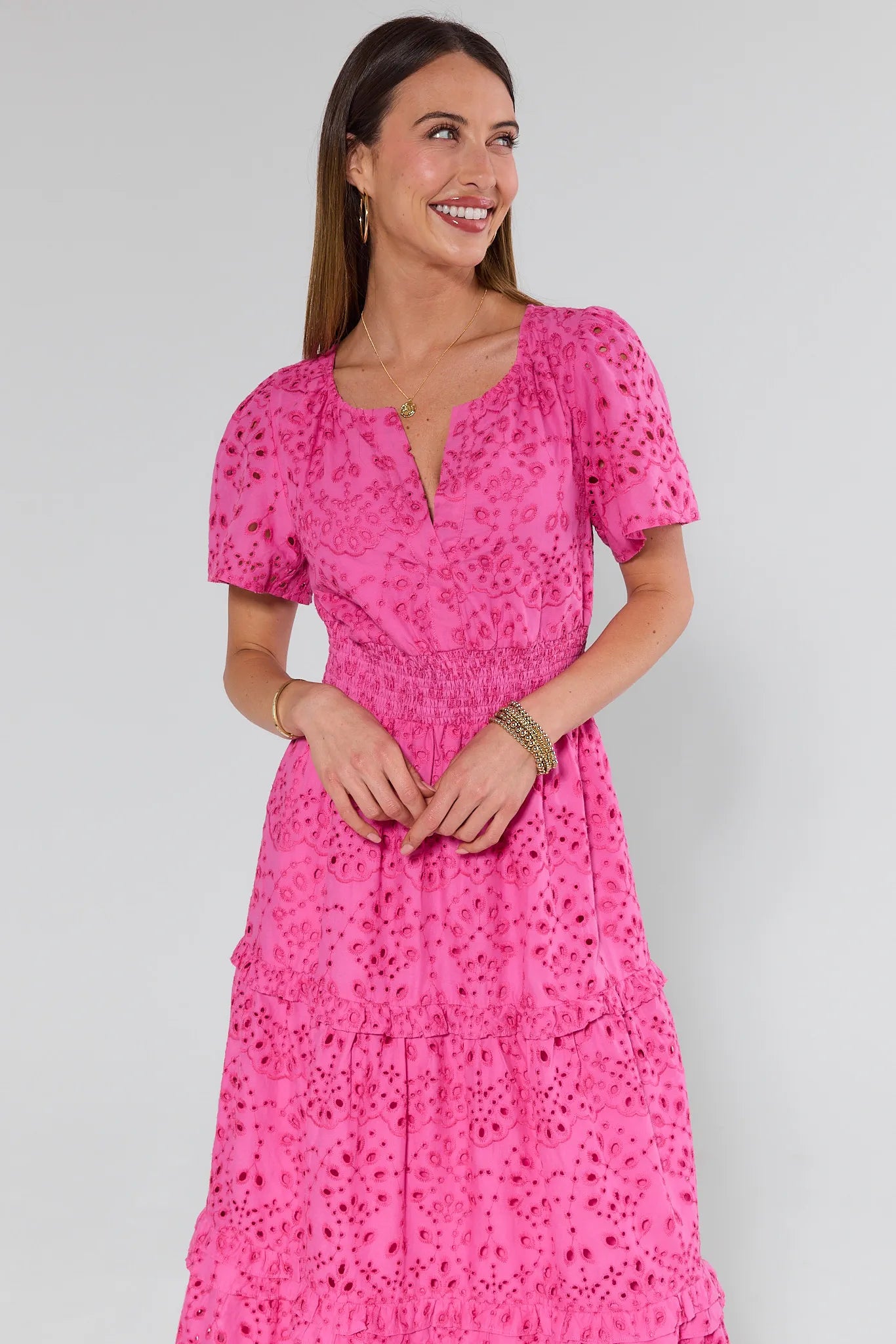 Woman wearing a pink floral dress against a white background