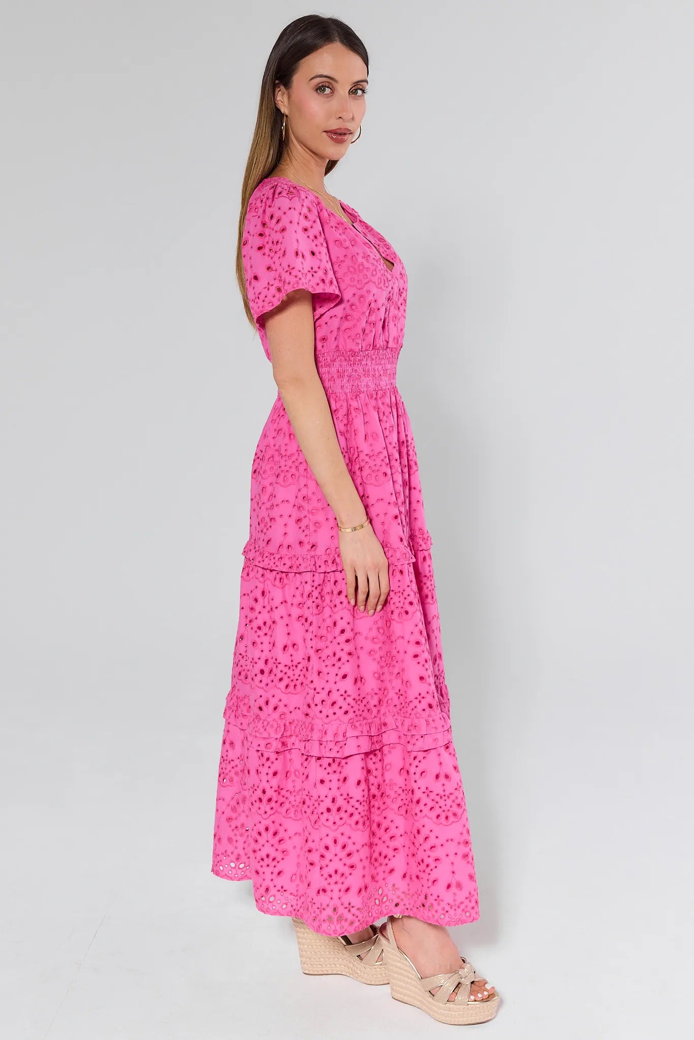 Woman wearing a pink dress with a floral pattern on a white background