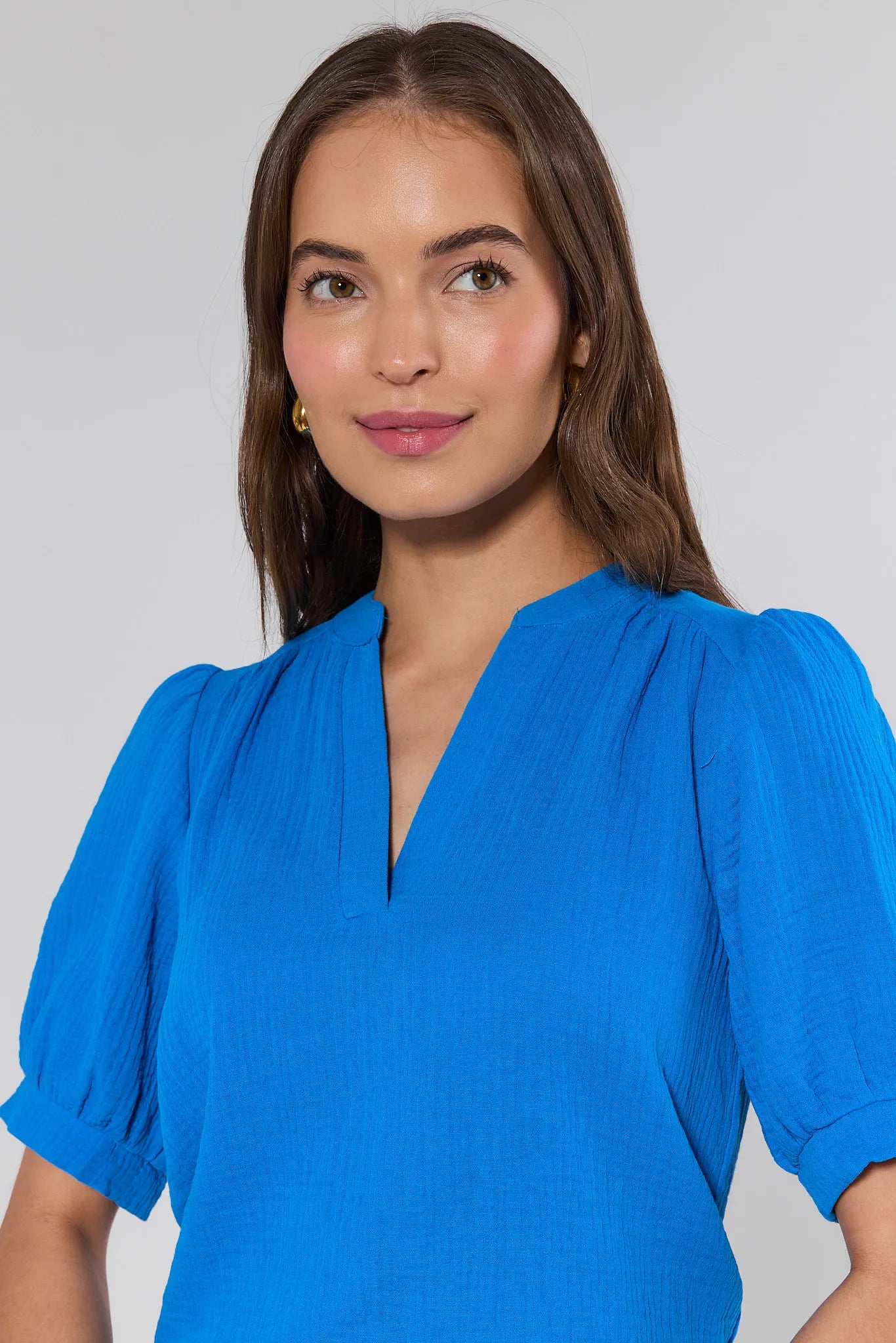 Woman wearing a blue blouse against a plain background