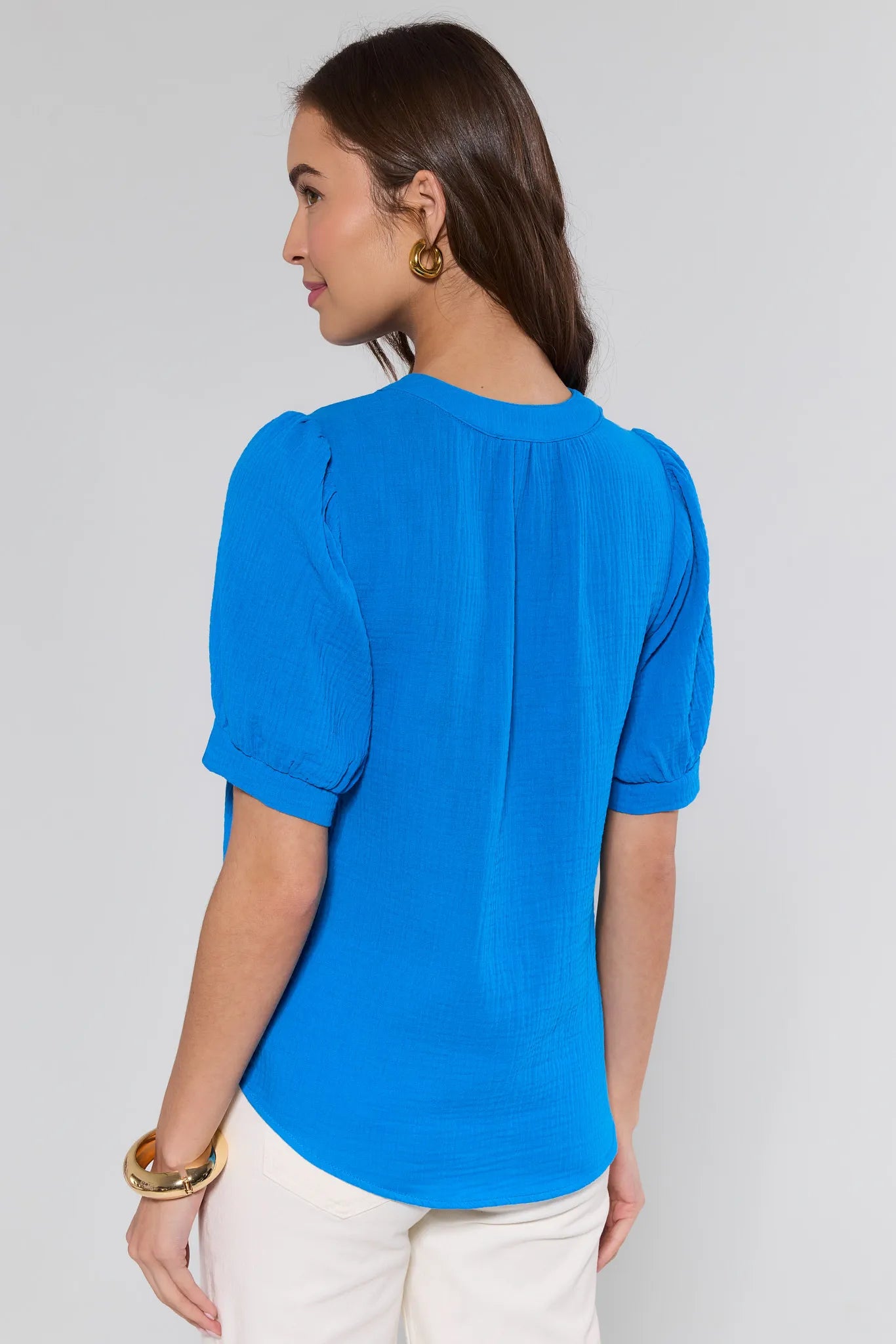 Woman wearing a blue top with a plain background