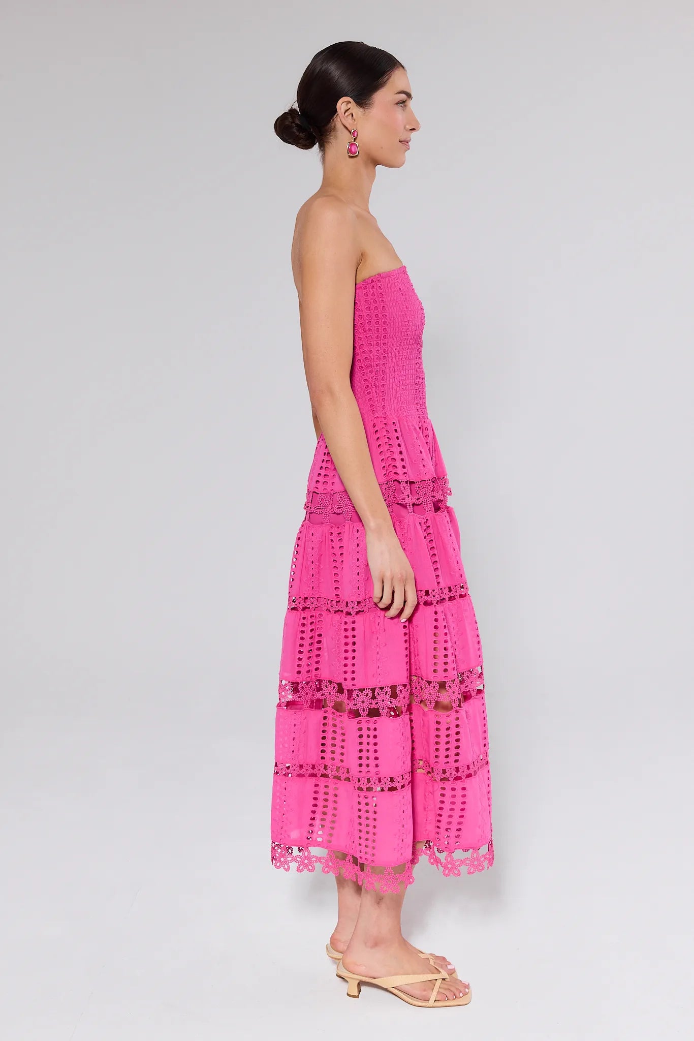 Woman wearing a pink strapless dress with a white background