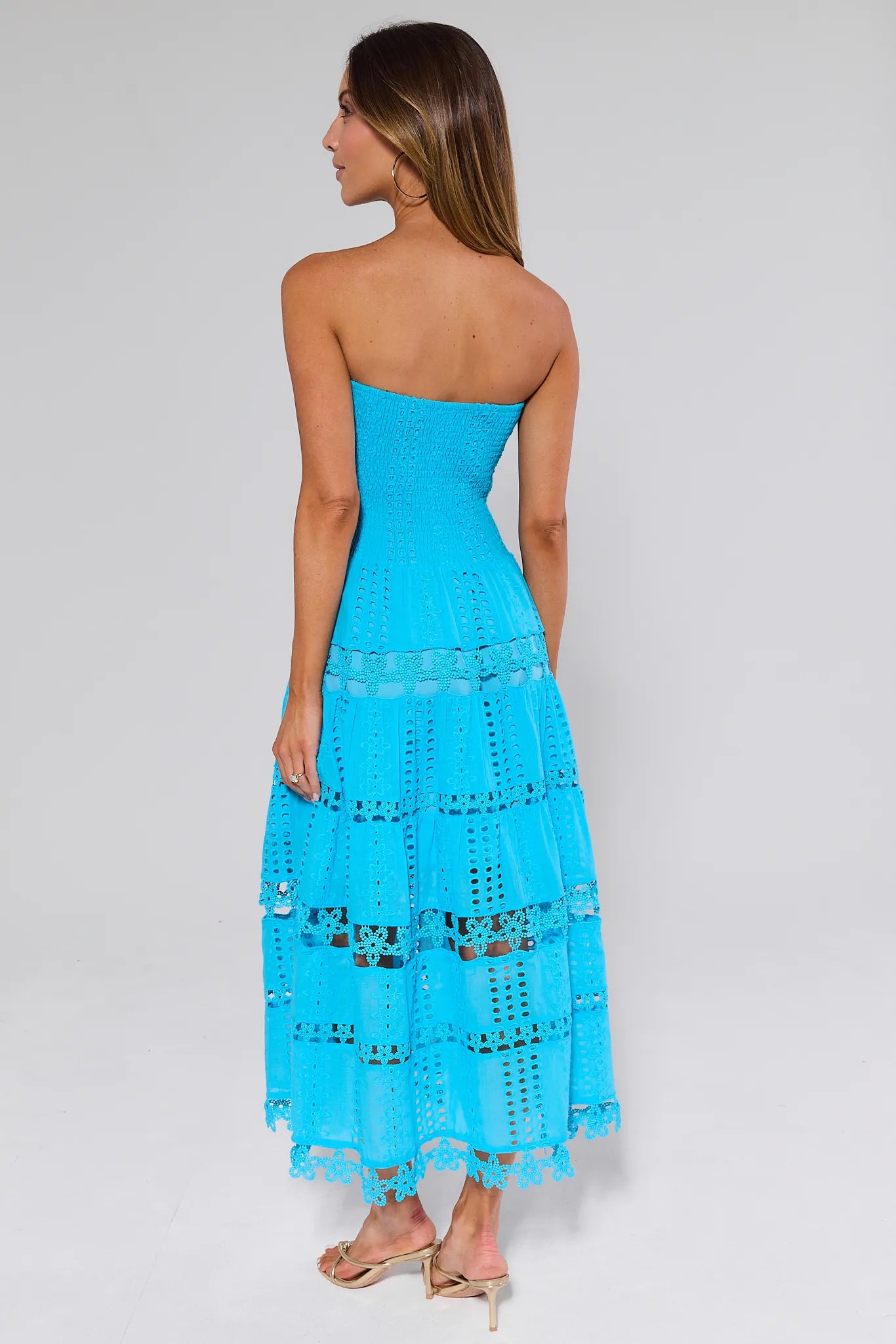 Woman wearing a Cecilia Blue Strapless Midi Dress with cut-out details on a white background