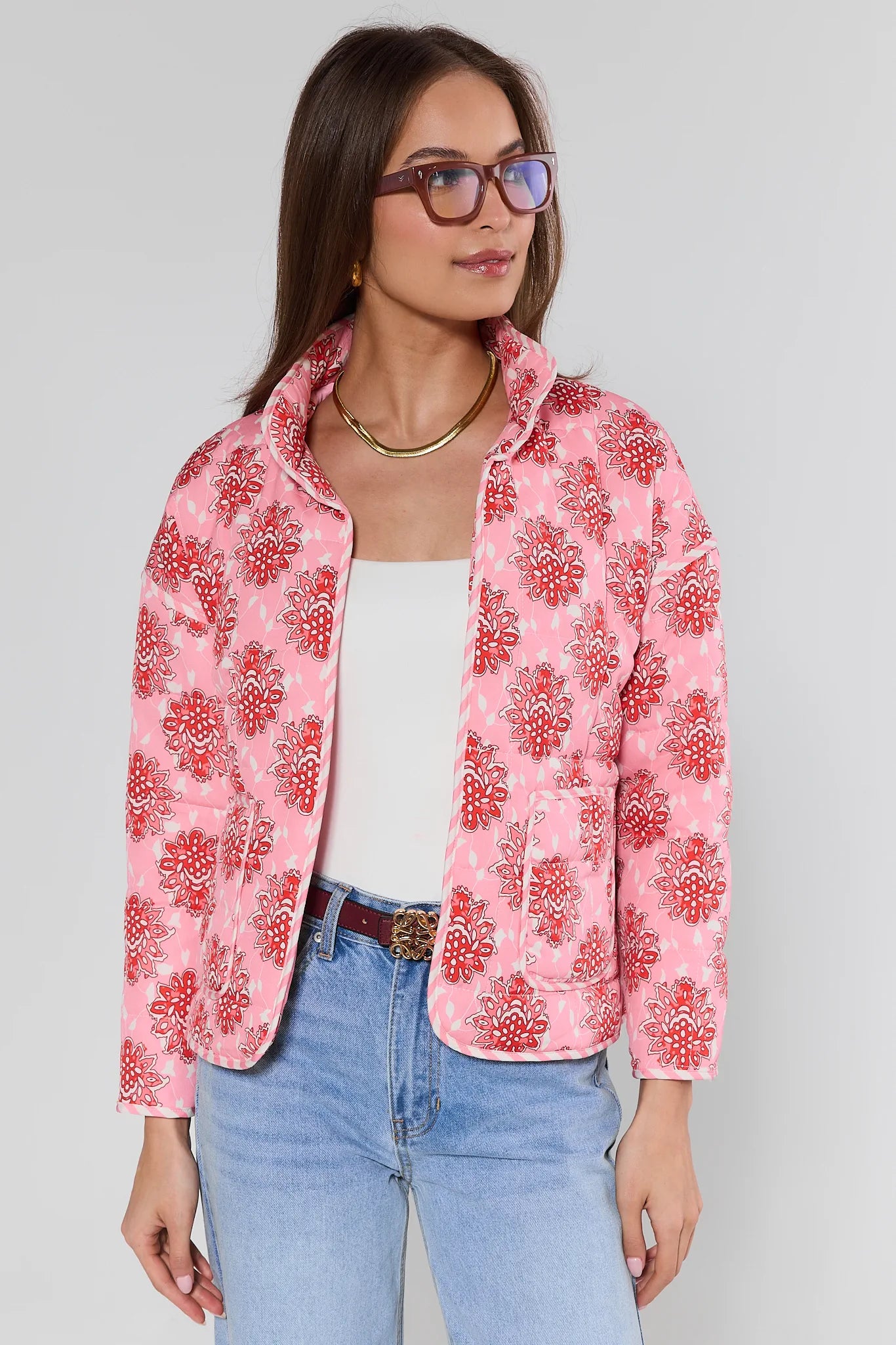 Woman wearing a pink floral jacket on a plain background