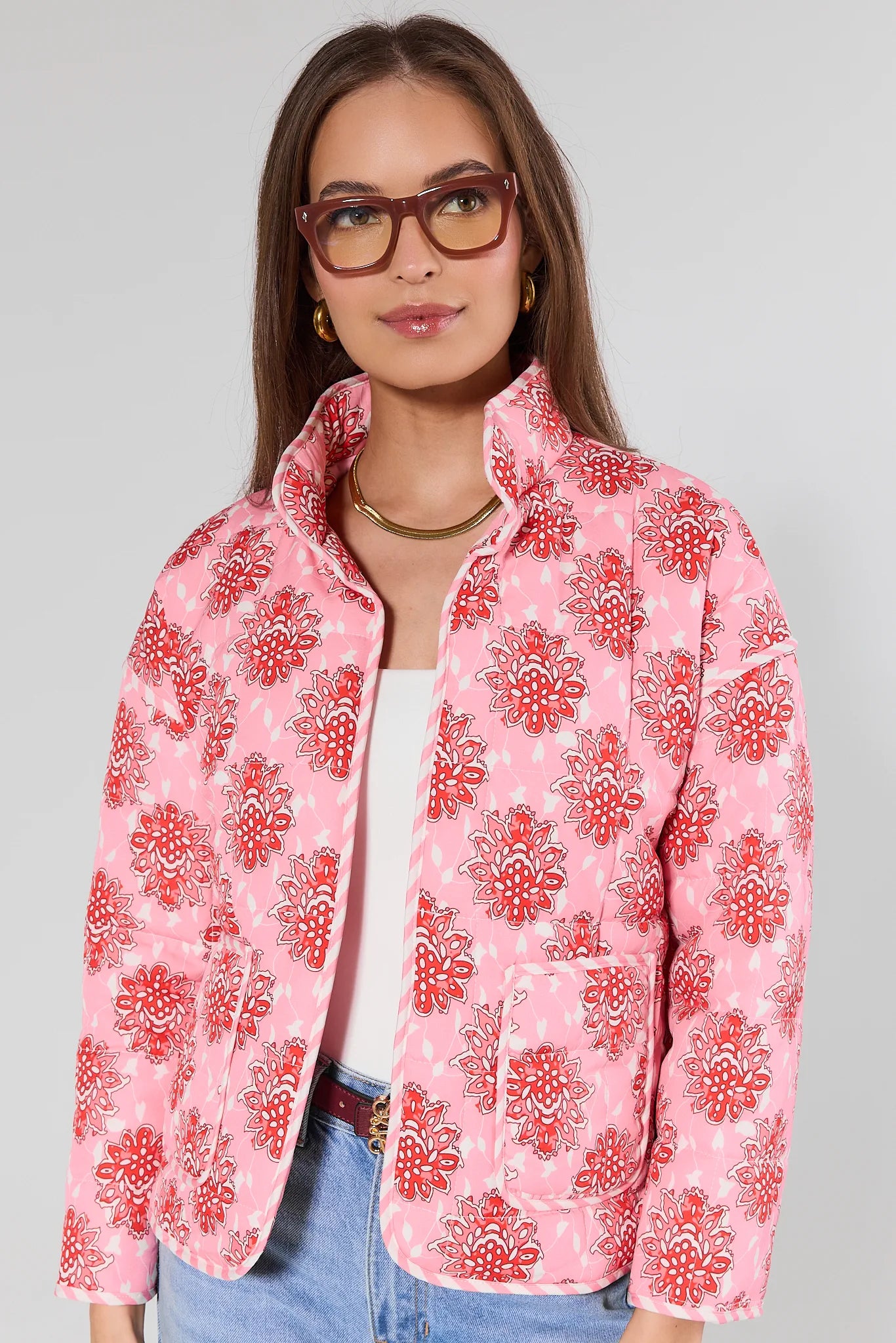 Woman wearing a pink floral jacket with a plain background