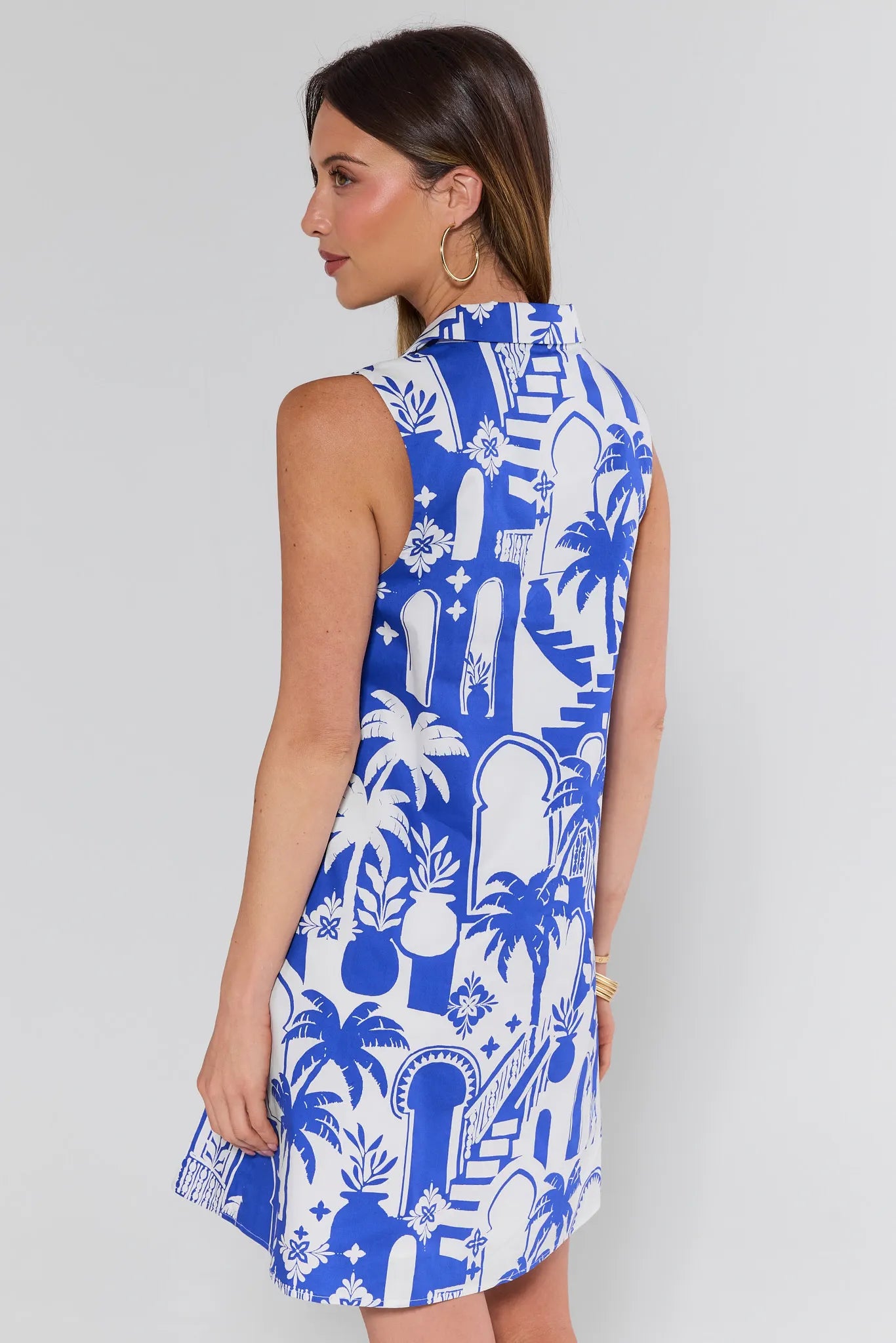 Woman wearing a blue and white patterned dress on a plain background