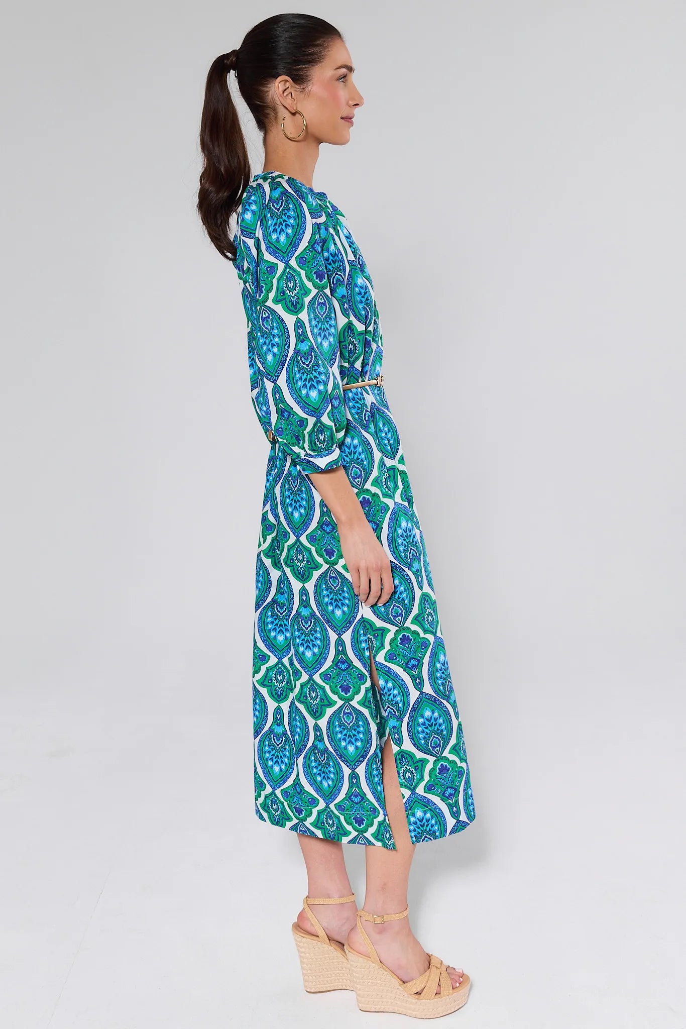 Woman wearing a blue and green patterned dress on a white background