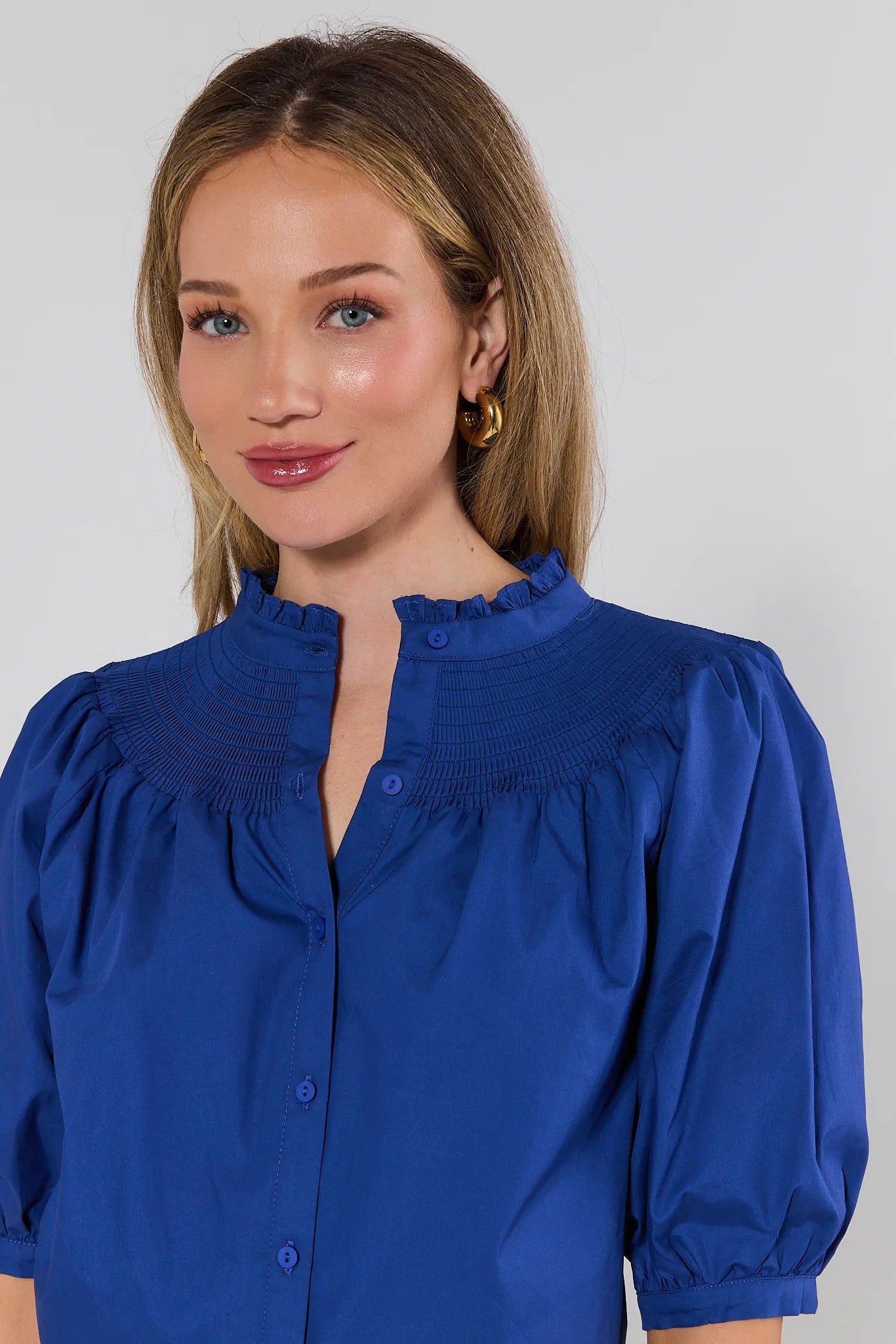 Woman wearing a blue blouse against a white background