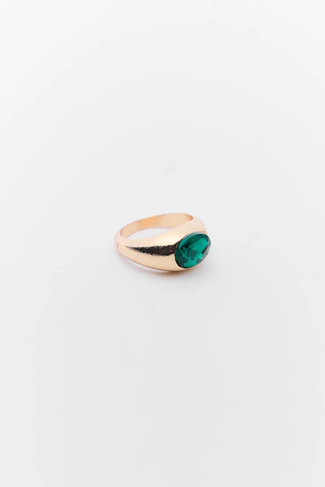 Gold ring with a green gemstone on a white background