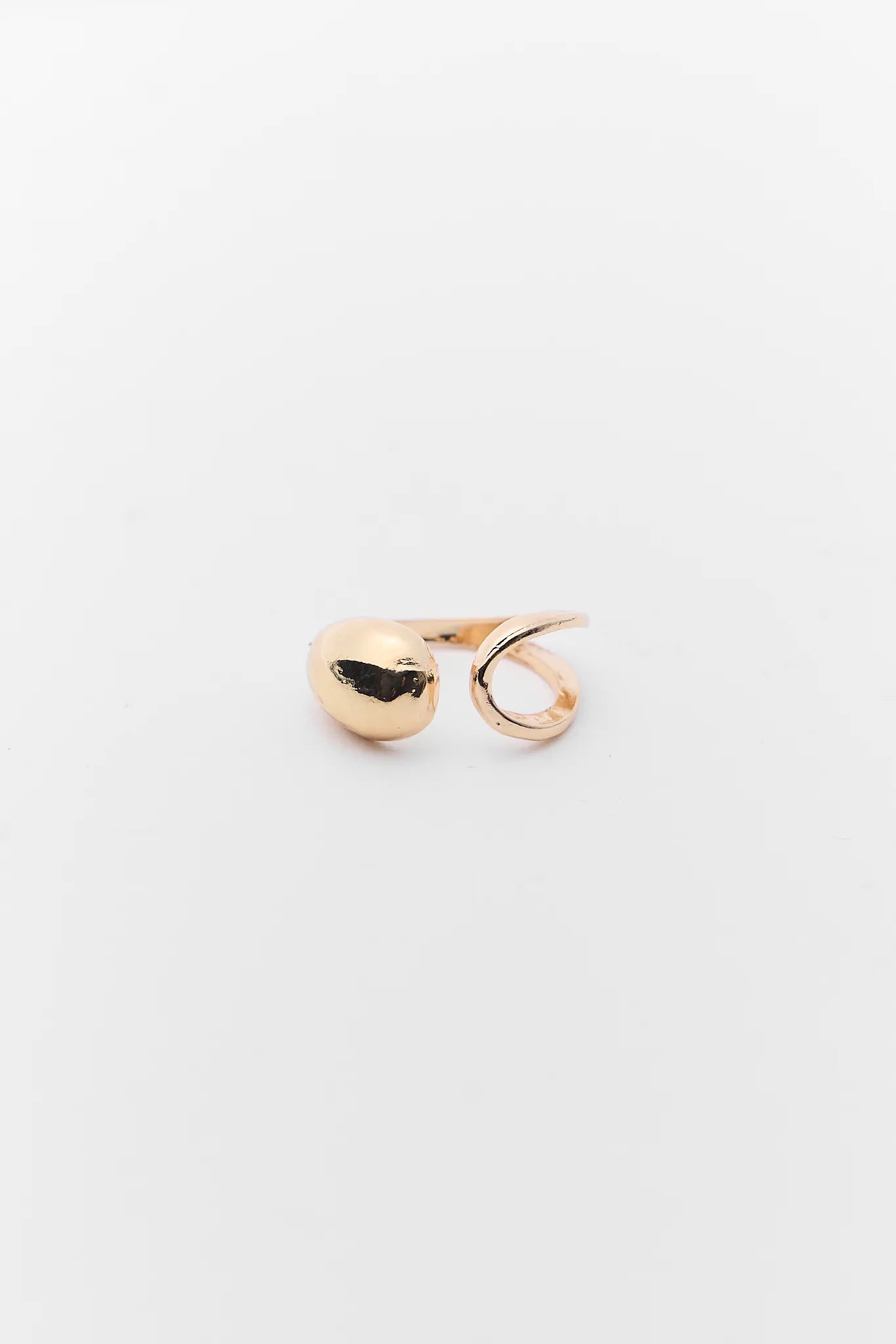 Gold earring on a light gray background