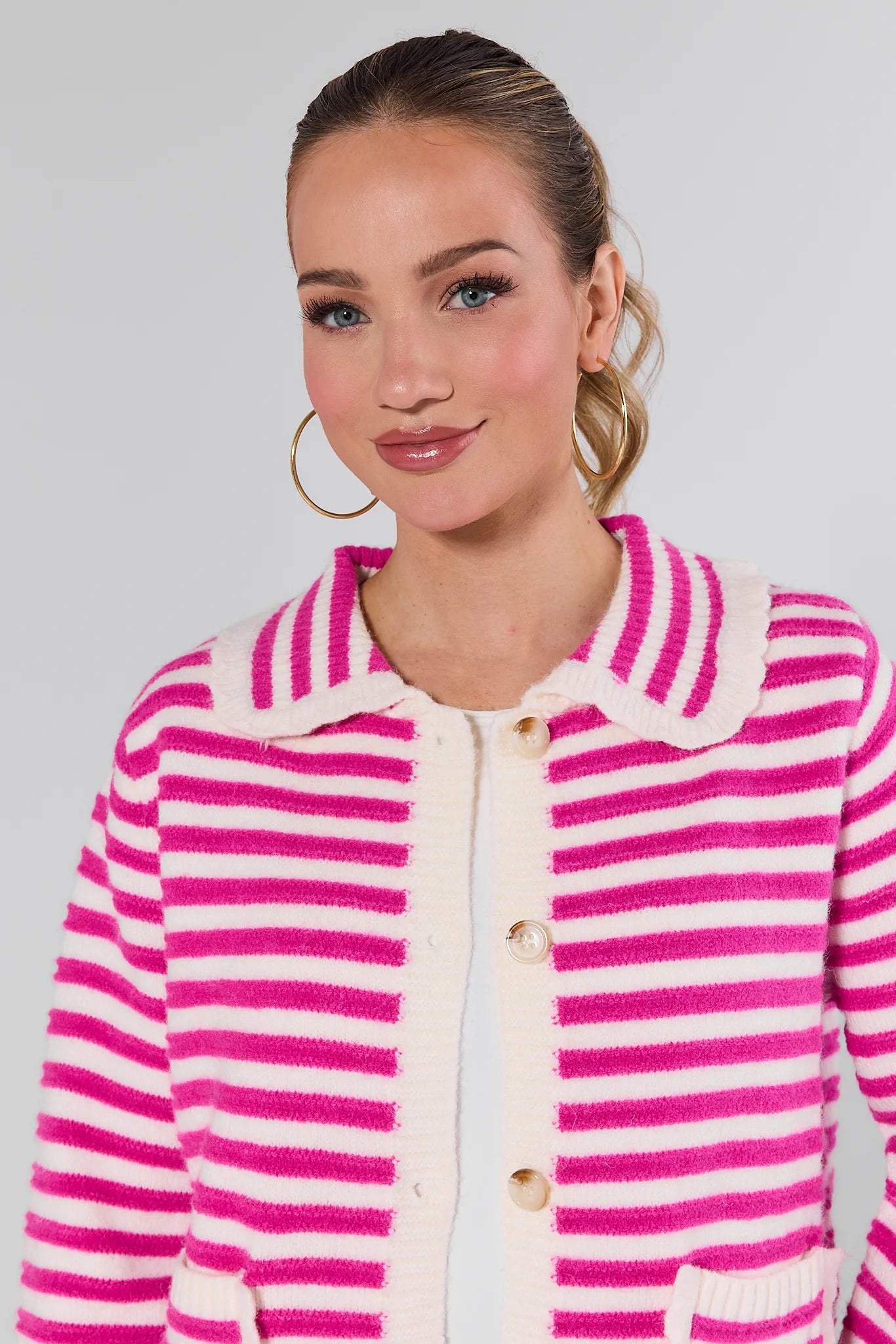 Woman wearing a Arlo Pink Striped Knit Cardigan against a plain background
