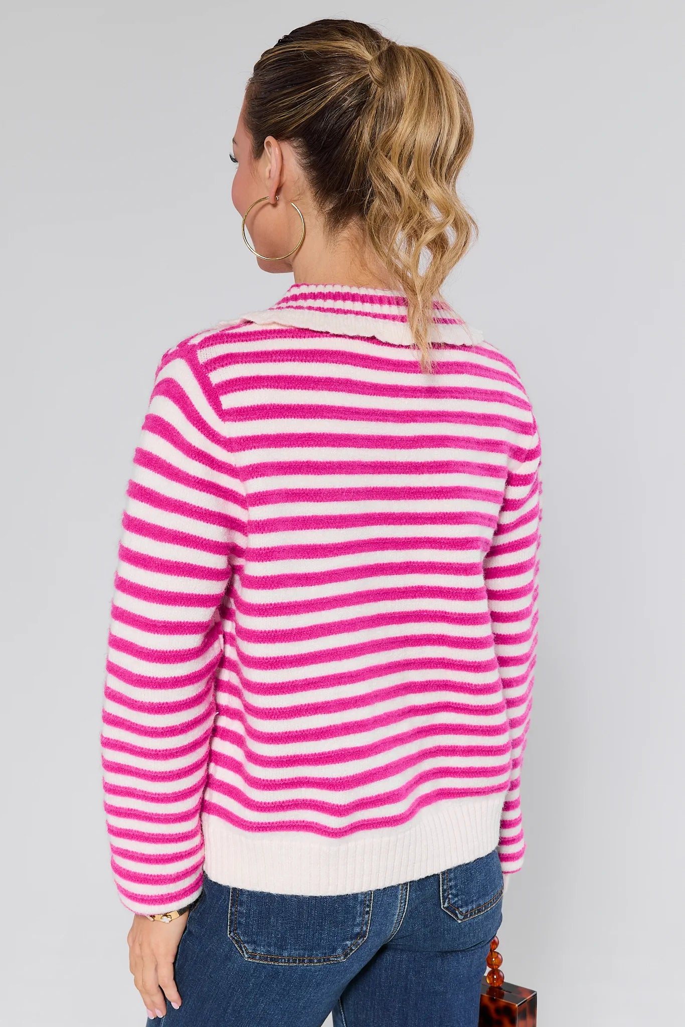 Woman wearing a Arlo Pink Striped Knit Cardigan against a plain background