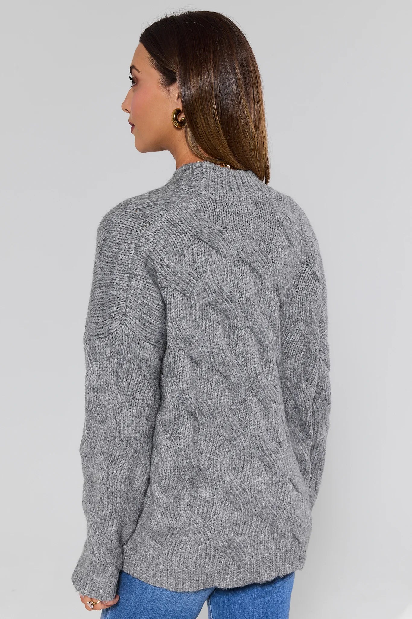 Woman wearing a Frankie Gray Cable Knit Cardigan on a light gray background