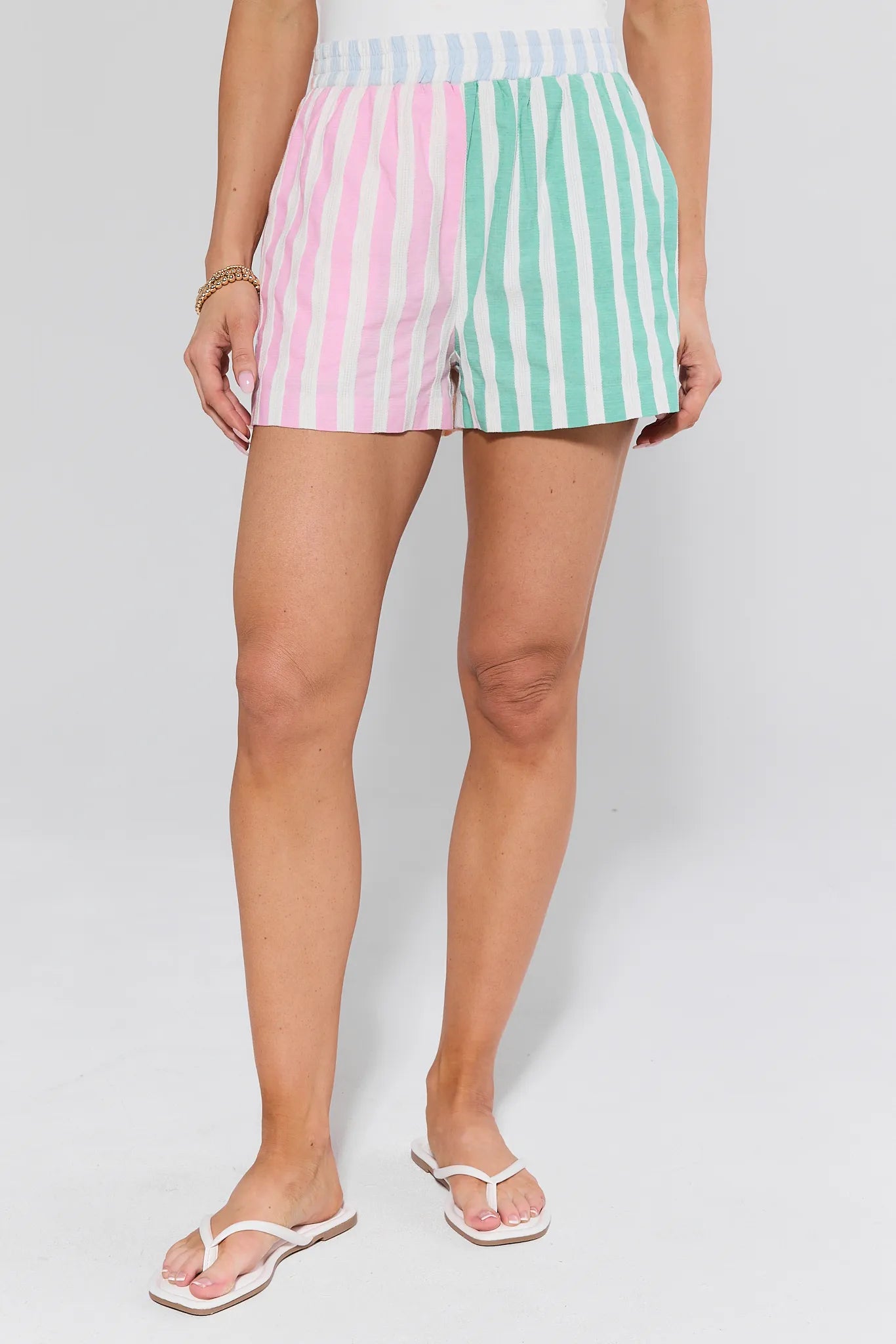 Pastel striped shorts worn by a person on a white background