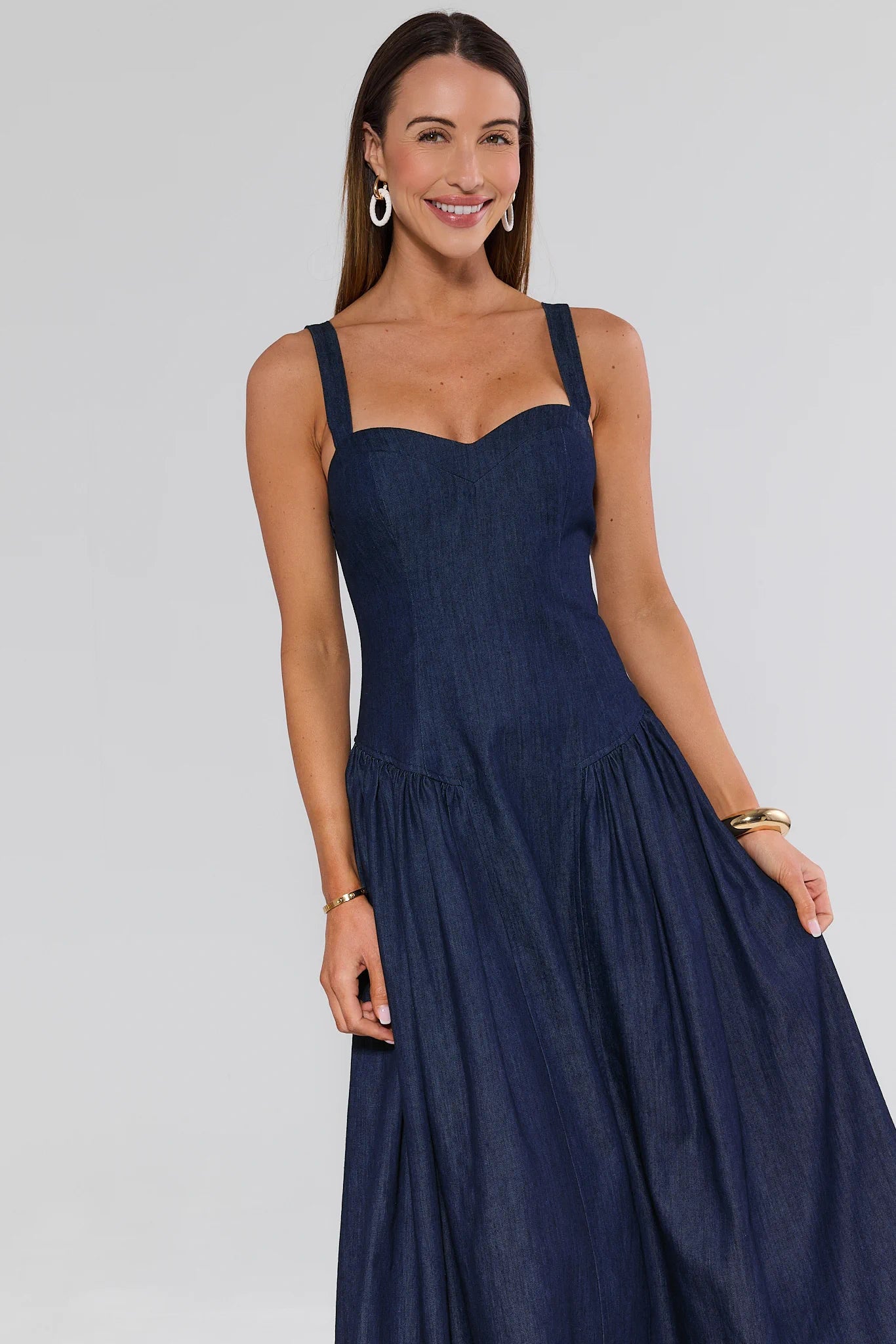 Woman wearing a navy blue dress against a plain background