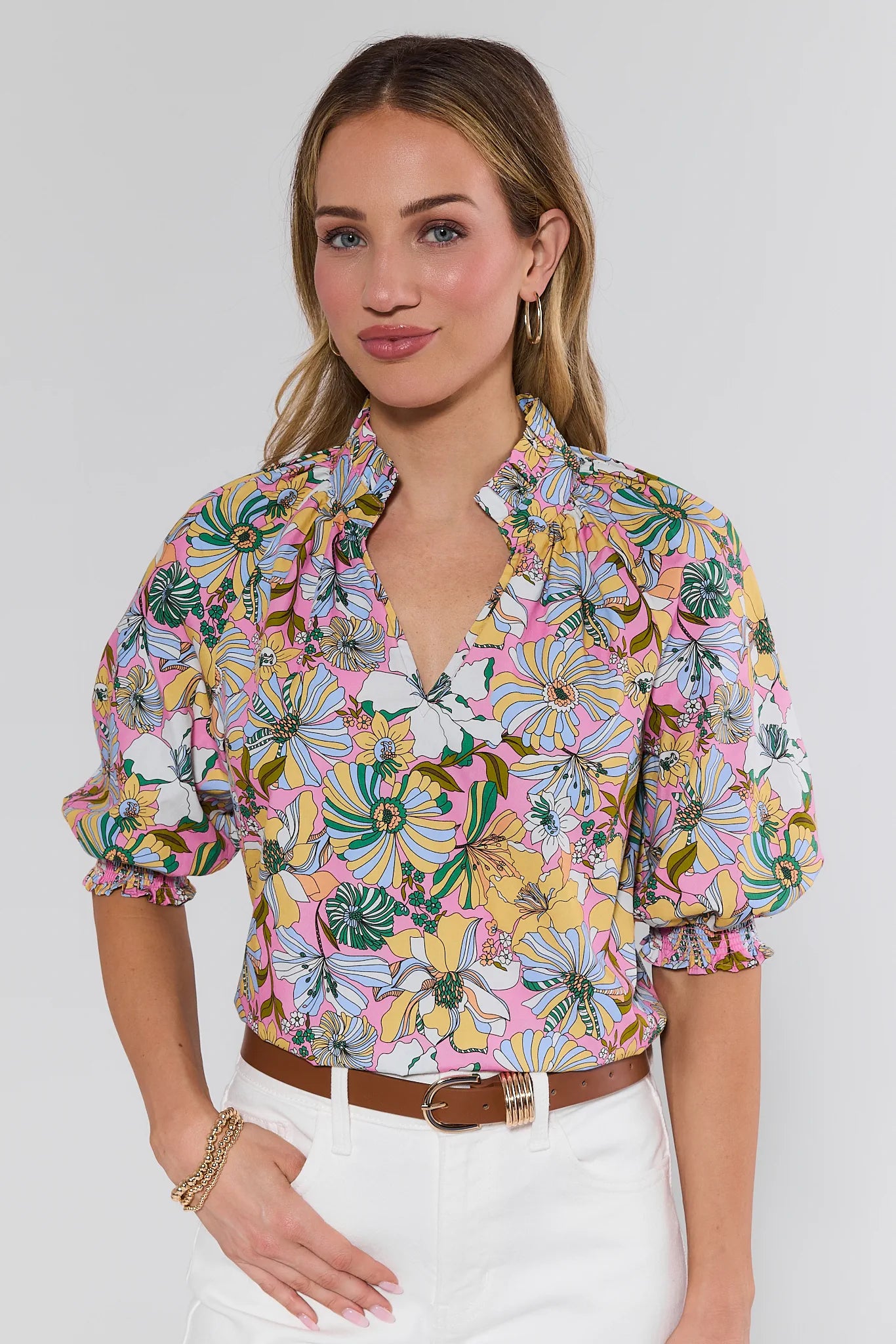Woman wearing a colorful floral blouse against a white background