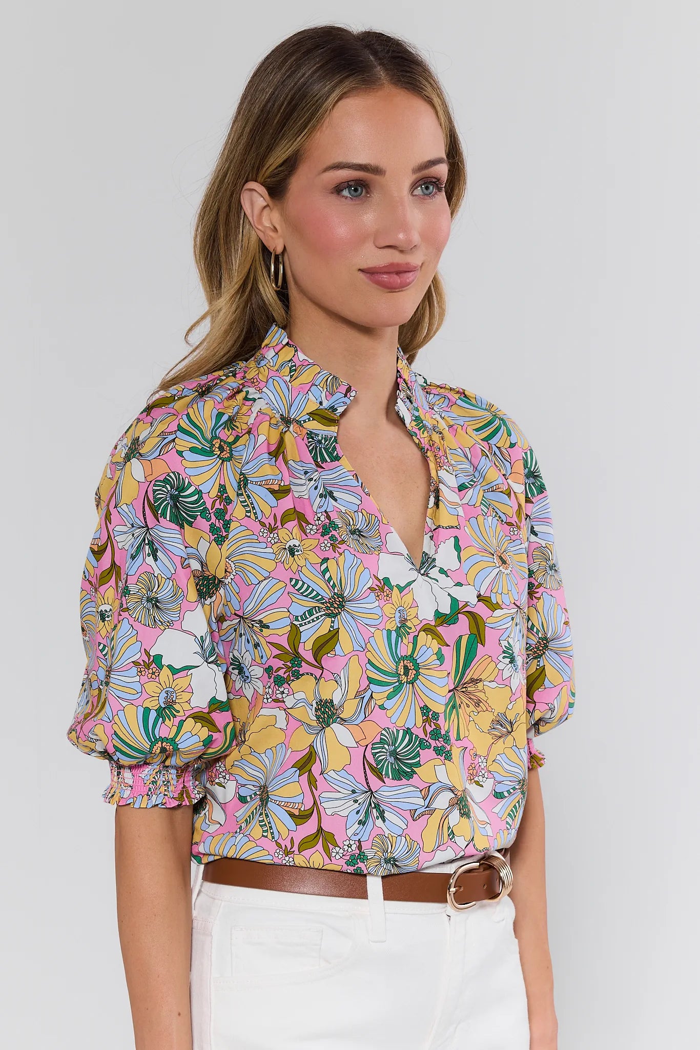 Woman wearing a colorful floral blouse against a plain background