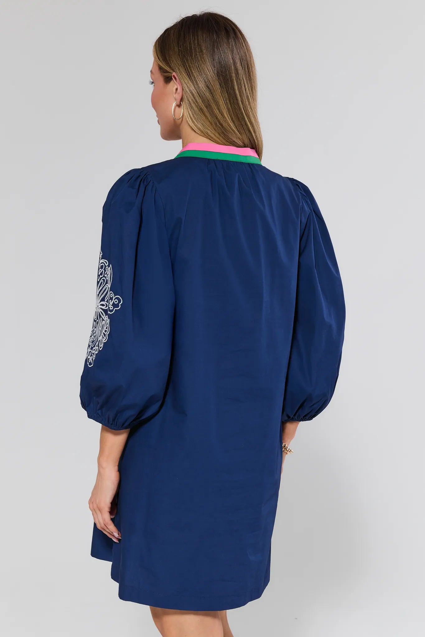 Navy blue dress with floral embroidery on a plain background