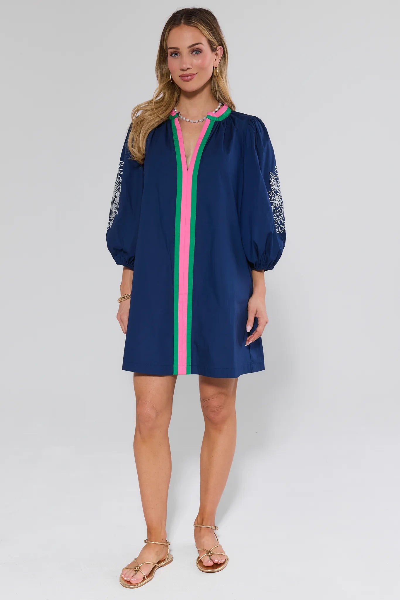 Woman wearing a blue dress with pink accents on a white background