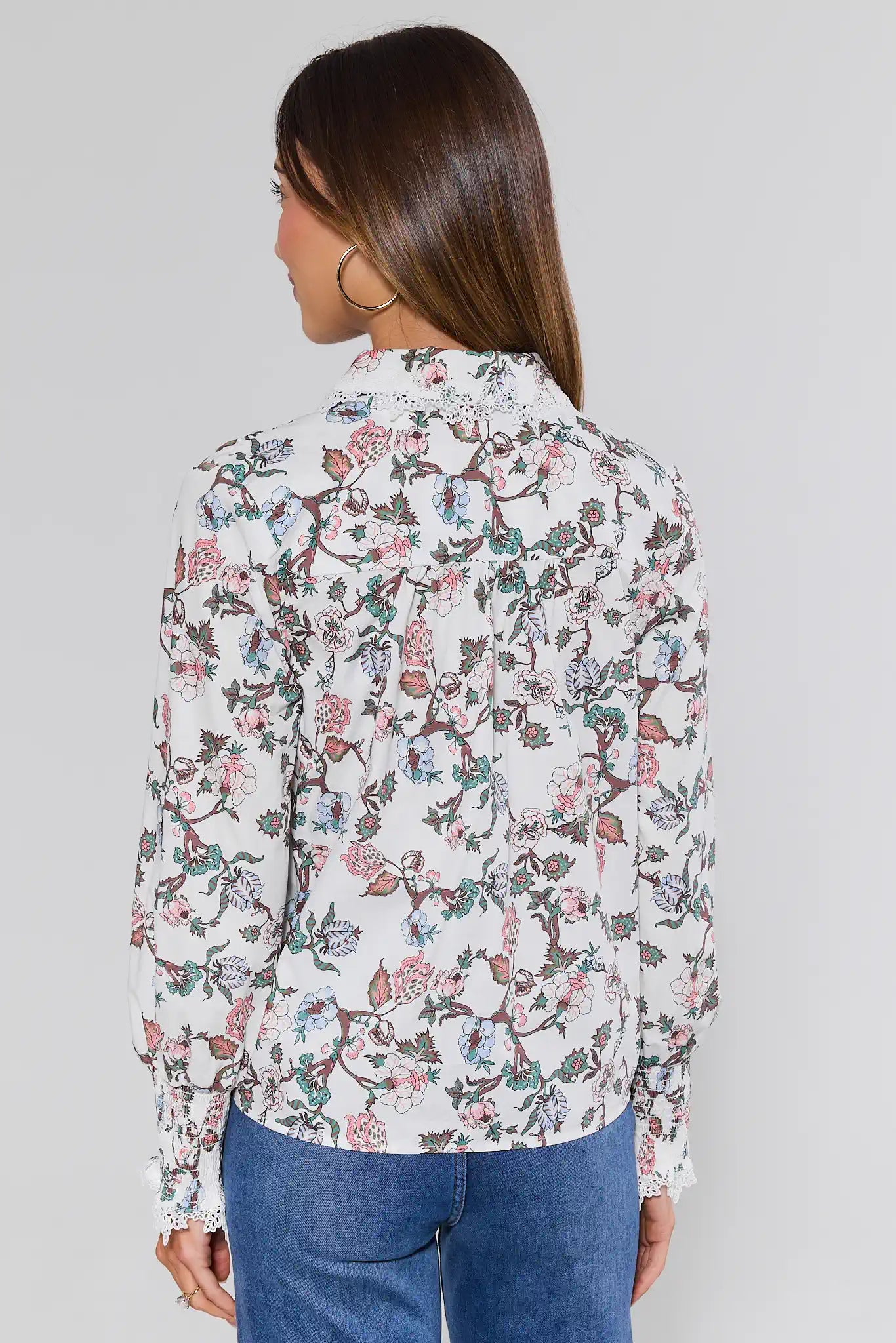 Woman wearing a floral blouse with a plain background