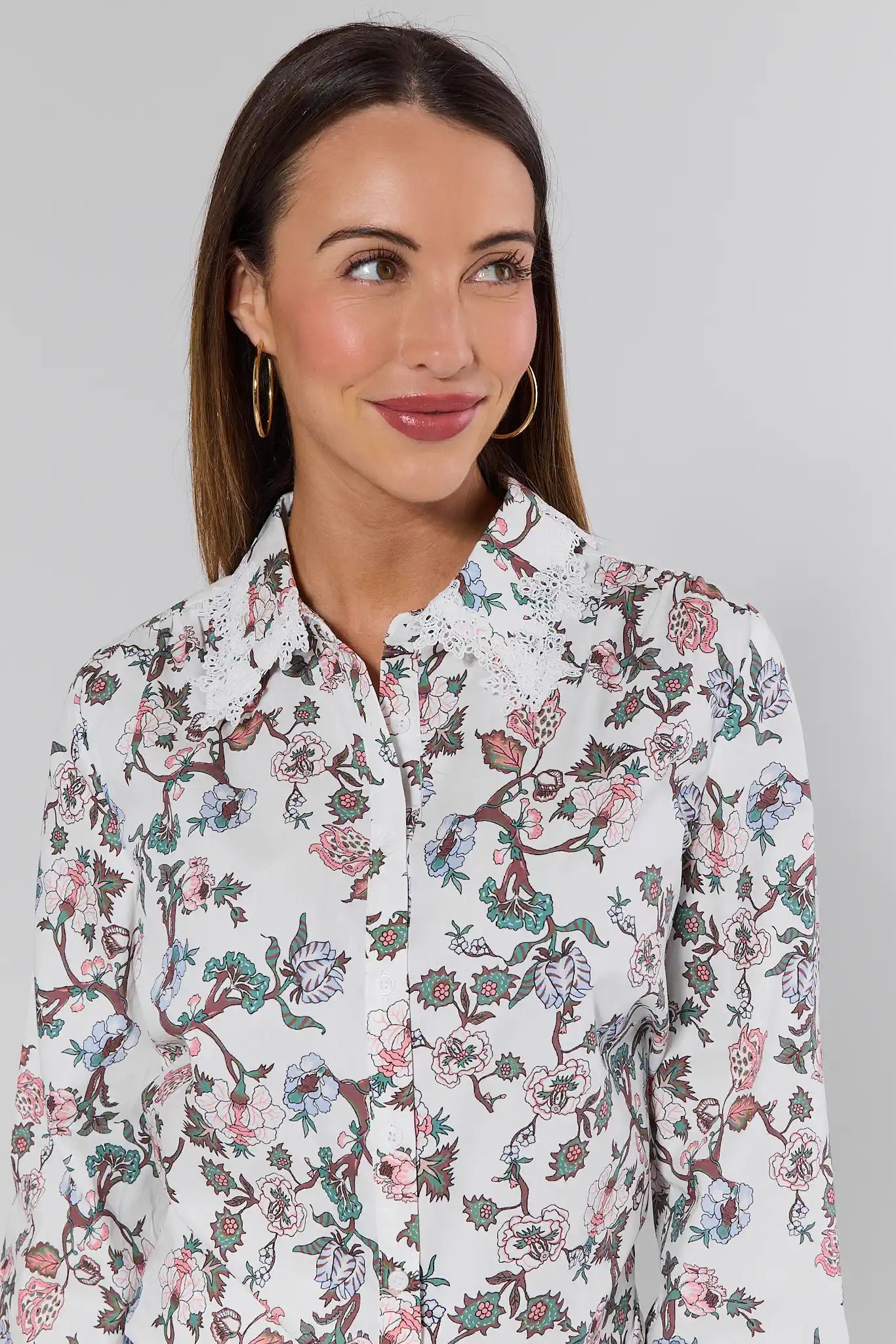 Woman wearing a floral patterned shirt against a plain background