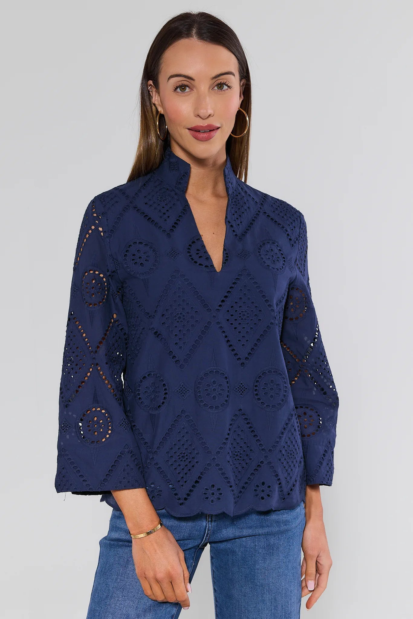 Woman wearing a navy blue lace top against a white background