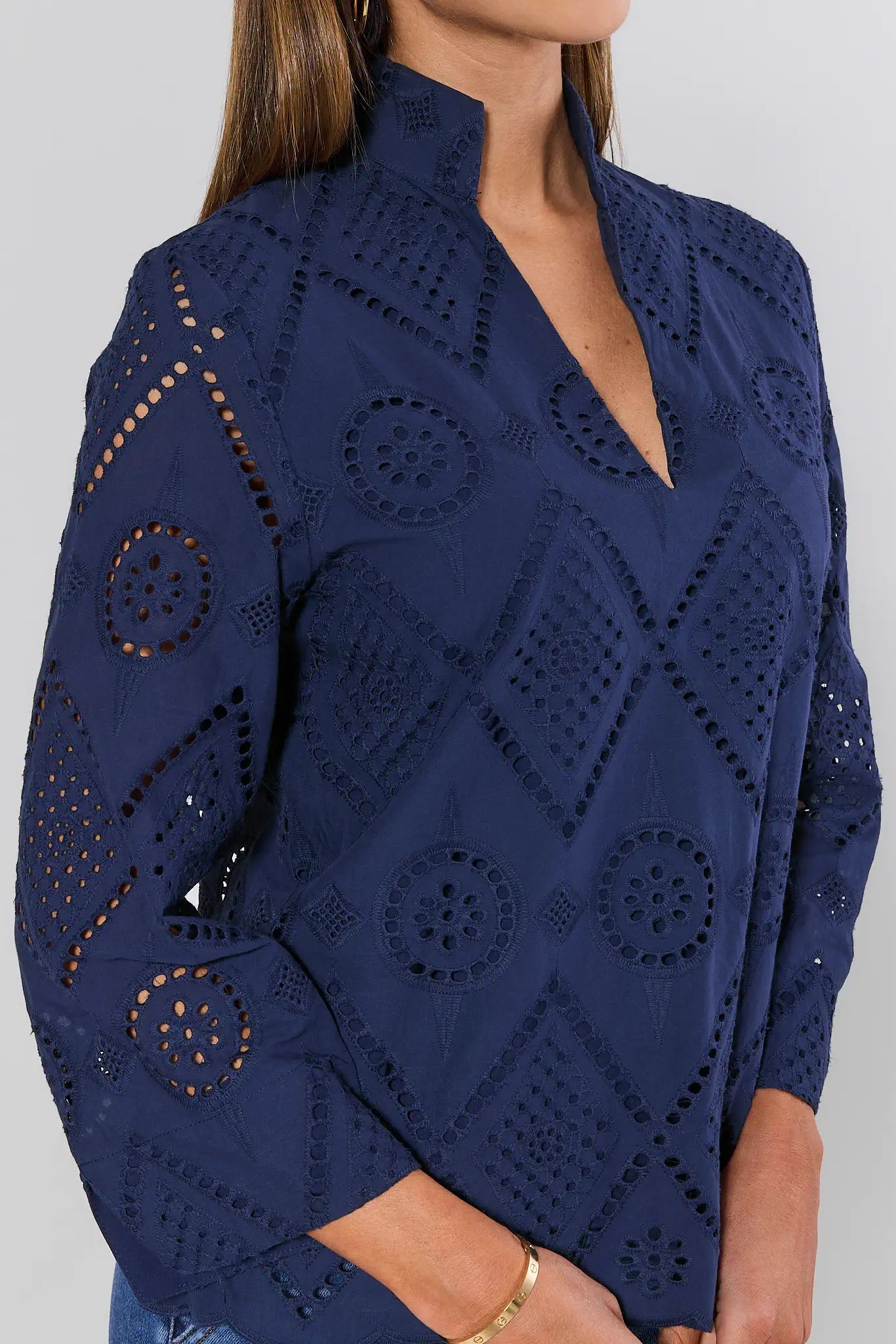 Navy blue sweater with intricate cut-out patterns on a plain background