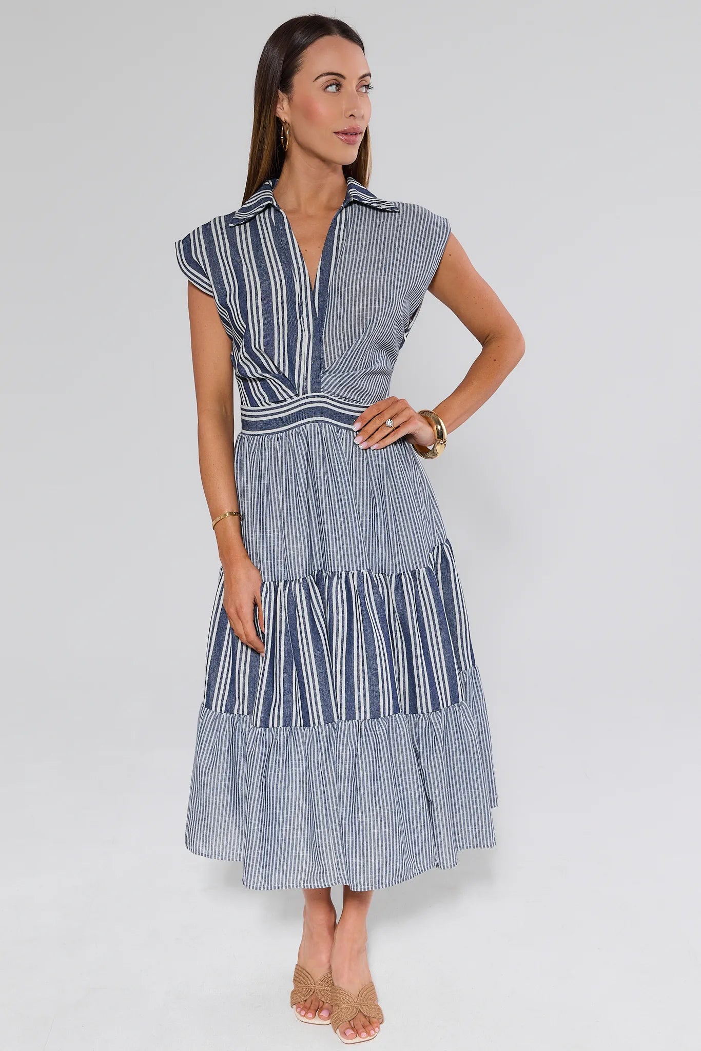 Woman wearing a blue and white striped dress on a white background