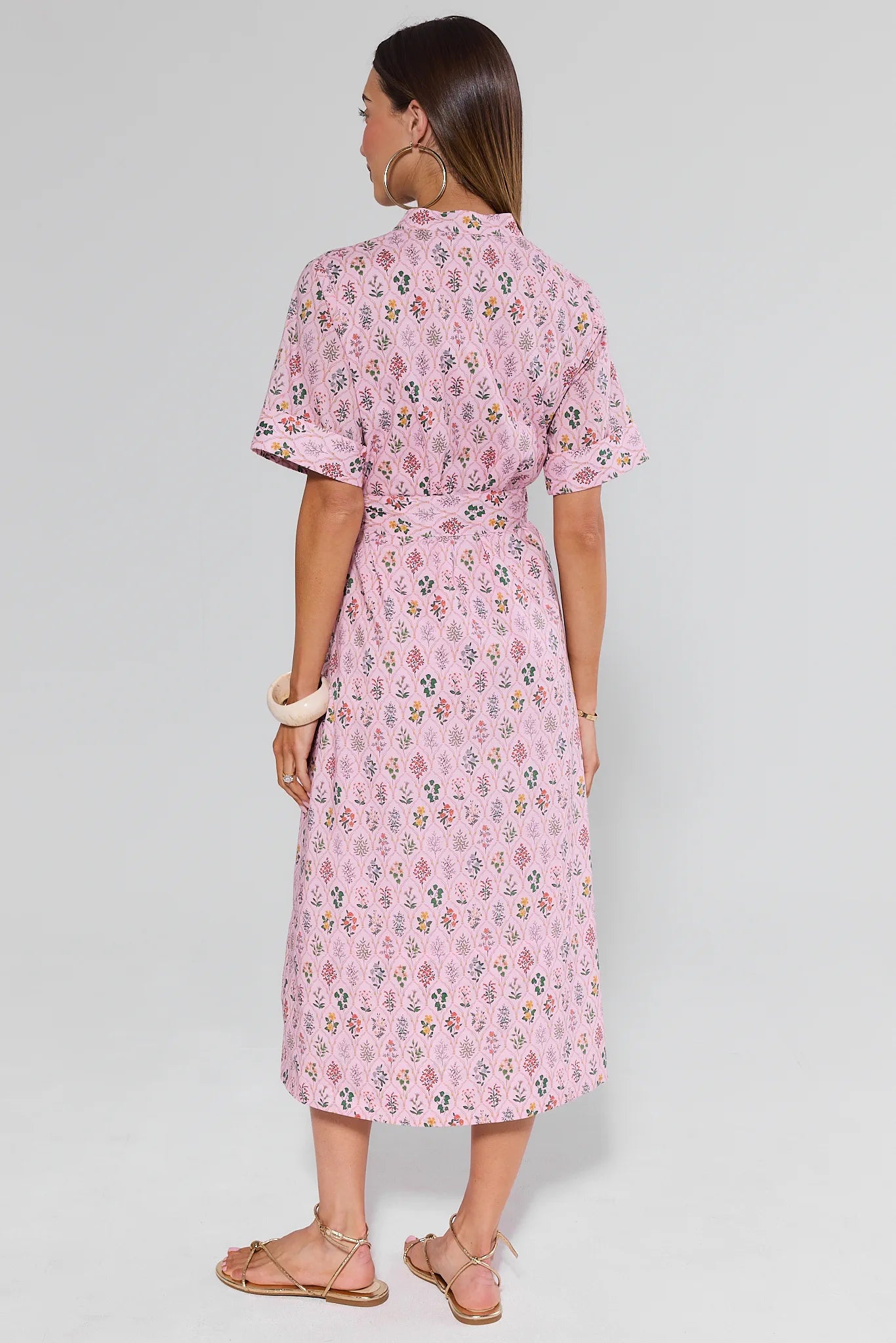 Woman wearing a pink floral dress on a white background