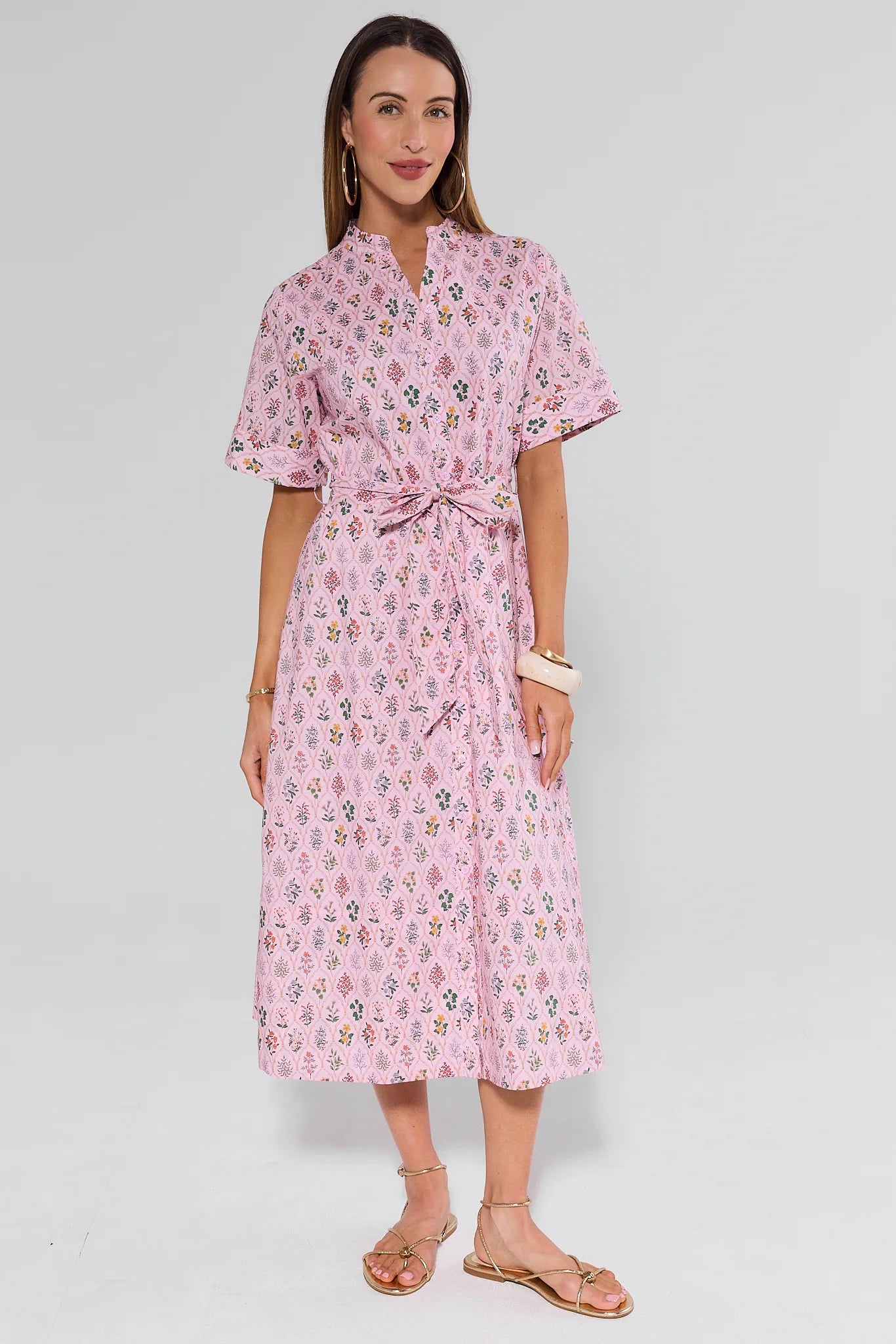 Woman wearing a pink floral dress on a white background