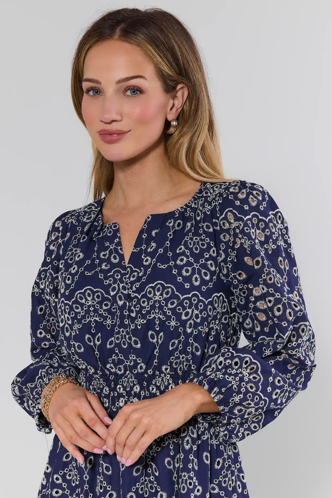 Woman wearing a blue patterned dress against a plain background
