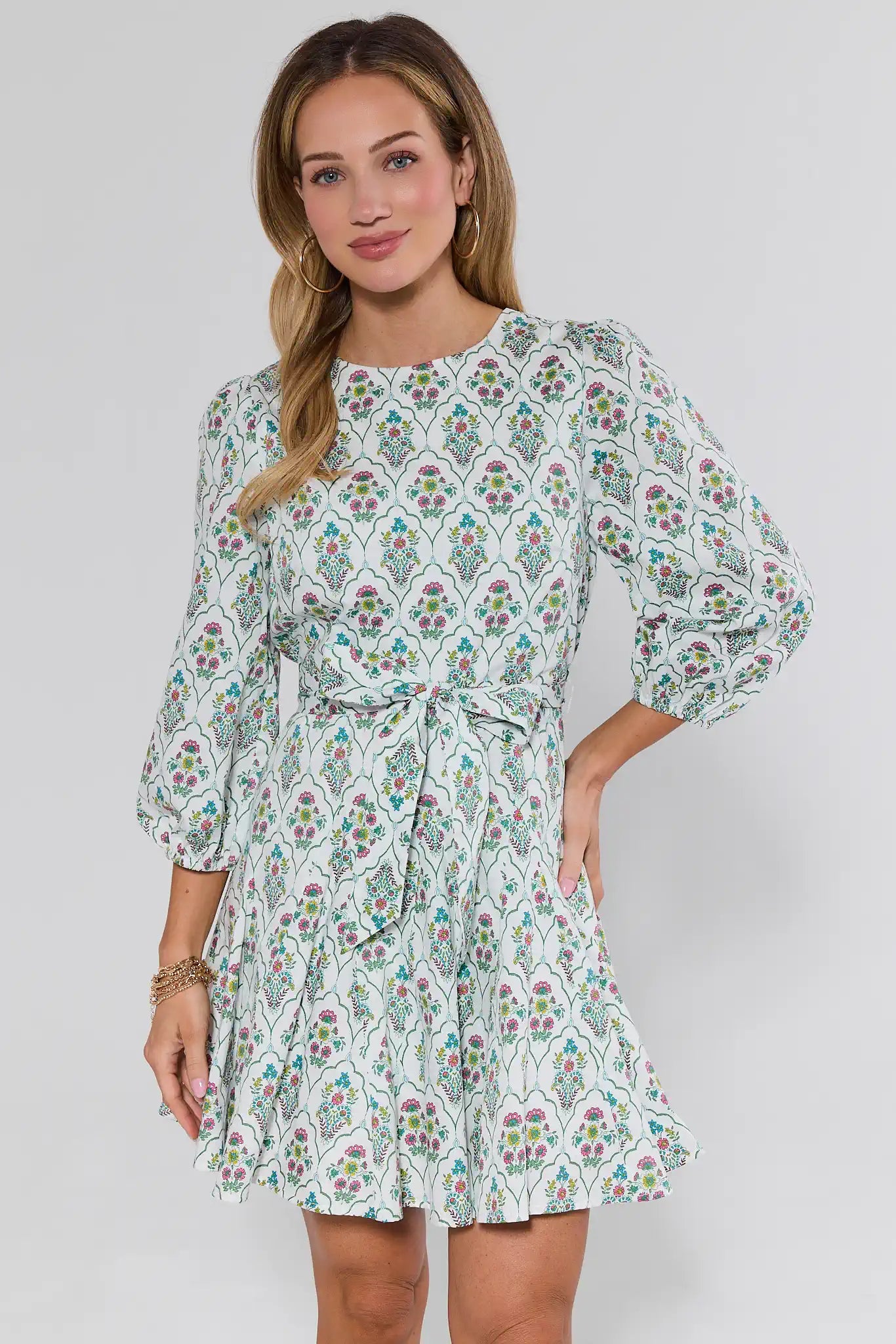 Woman wearing a floral dress against a plain background