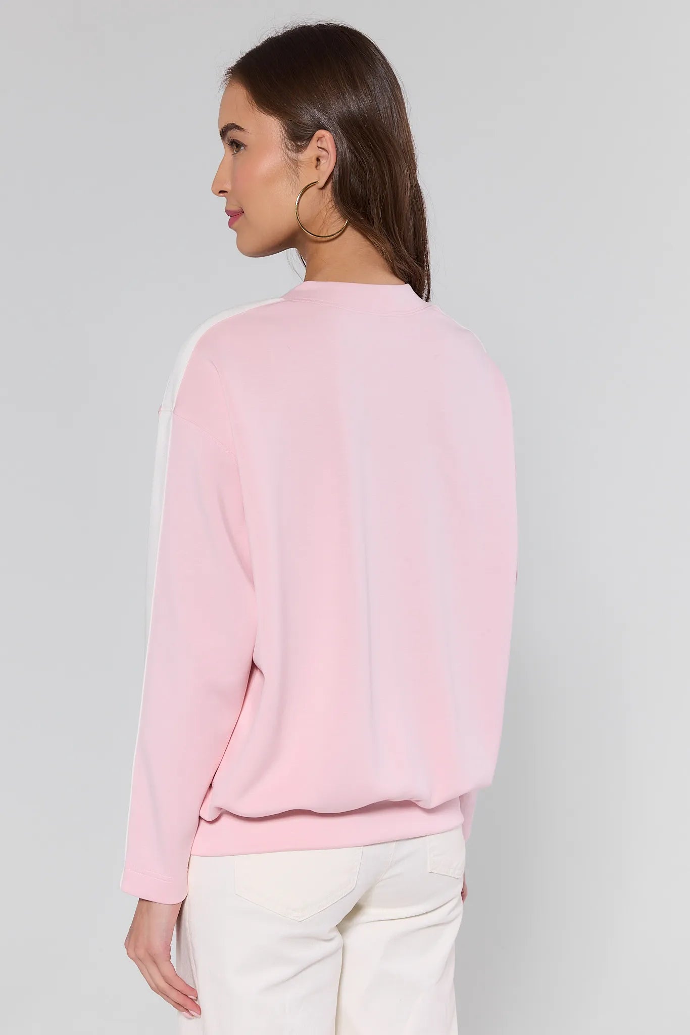 Woman wearing a pink sweater against a plain background