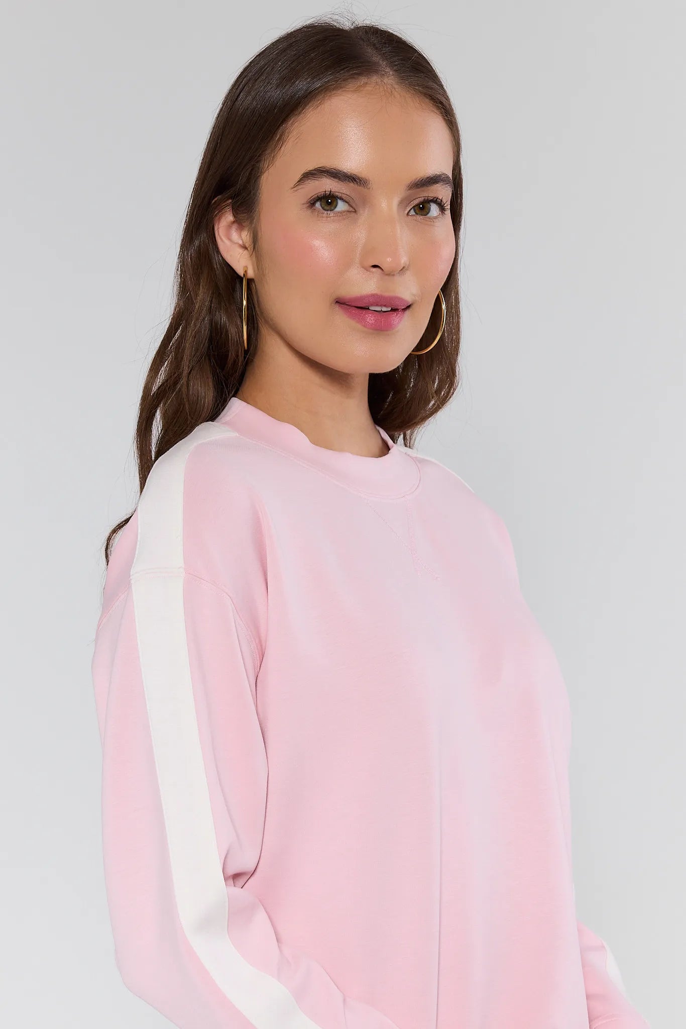 Woman wearing a pink and white against a plain background