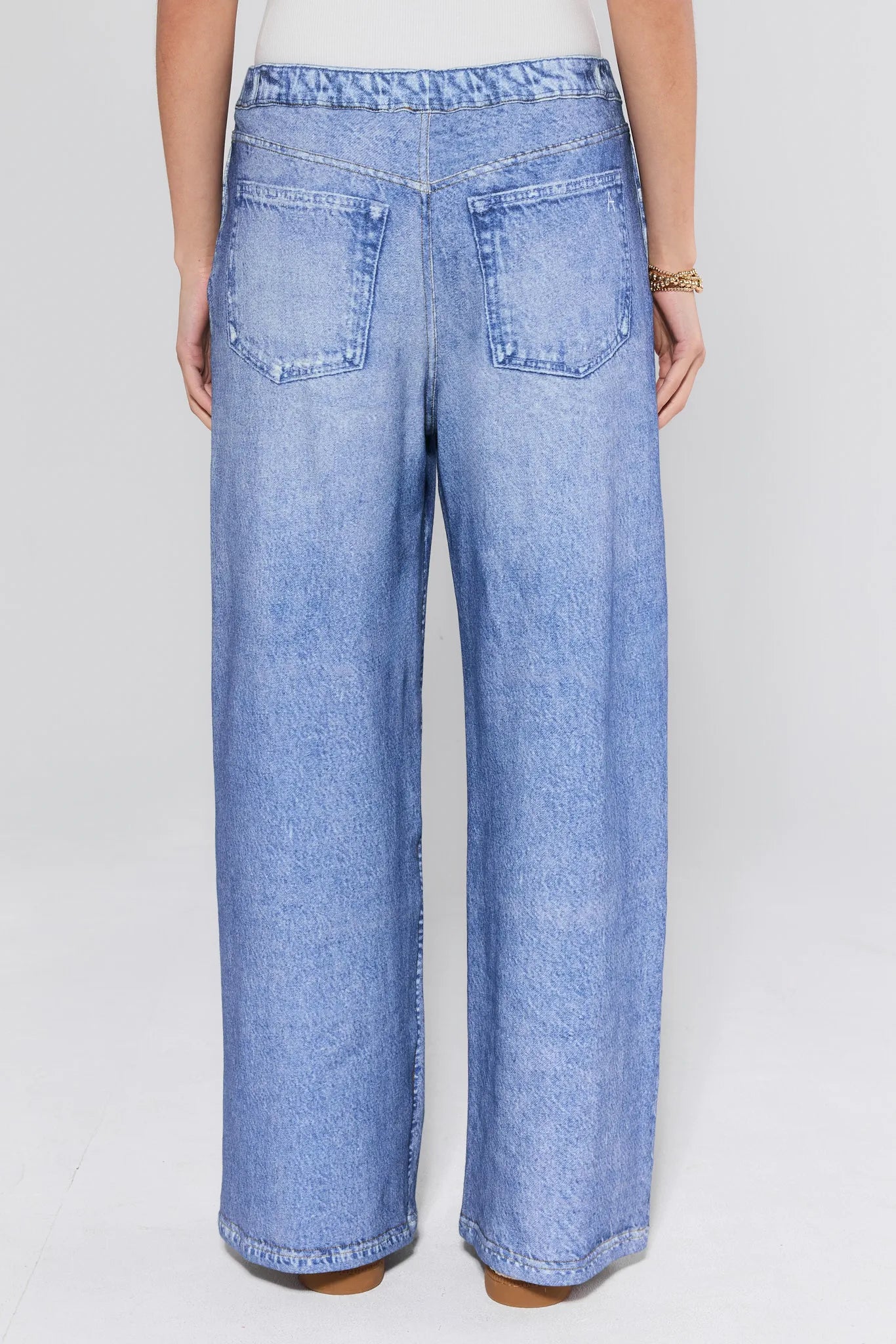 Light blue jeans worn by a person on a white background