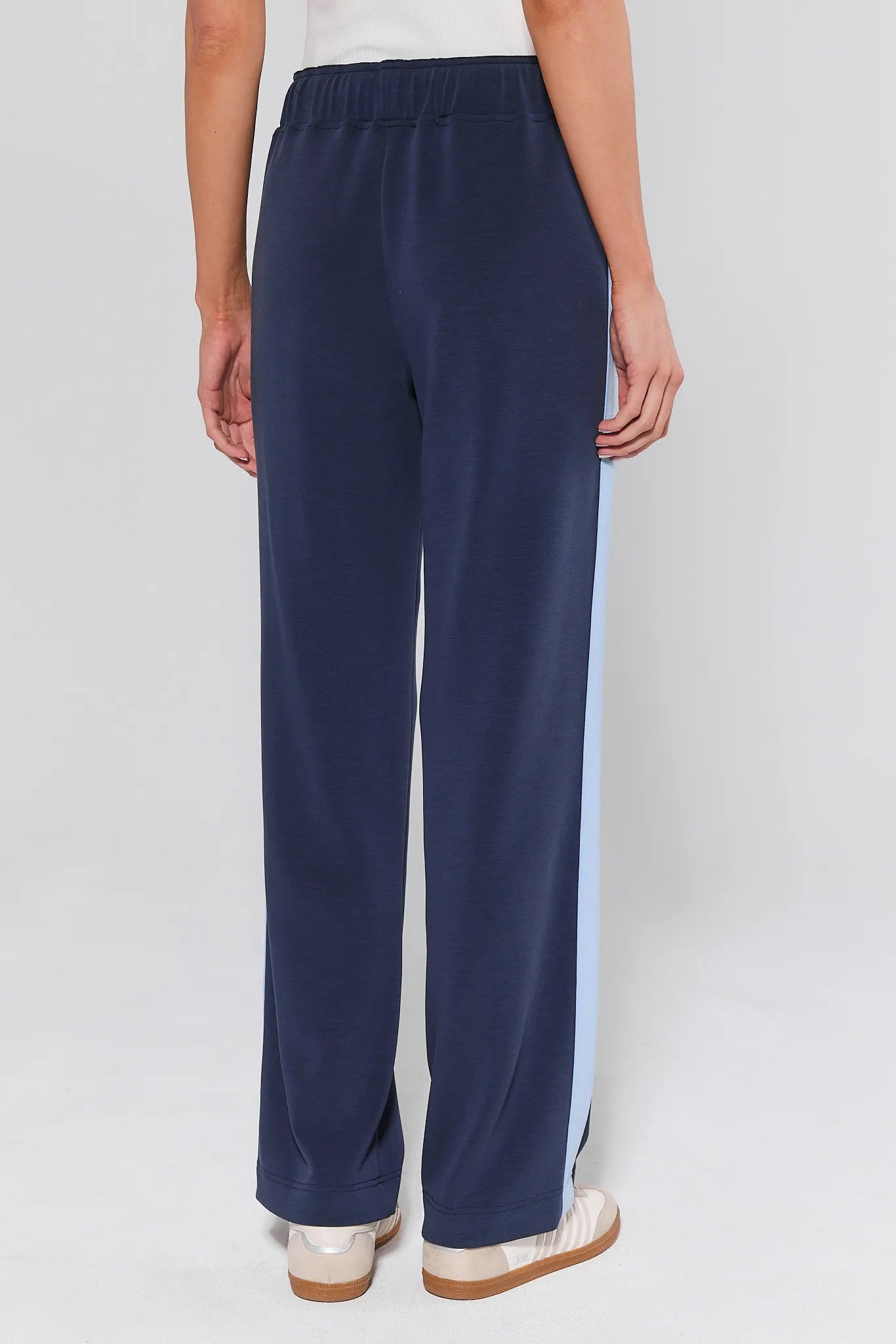 Navy blue pants worn by a person on a white background