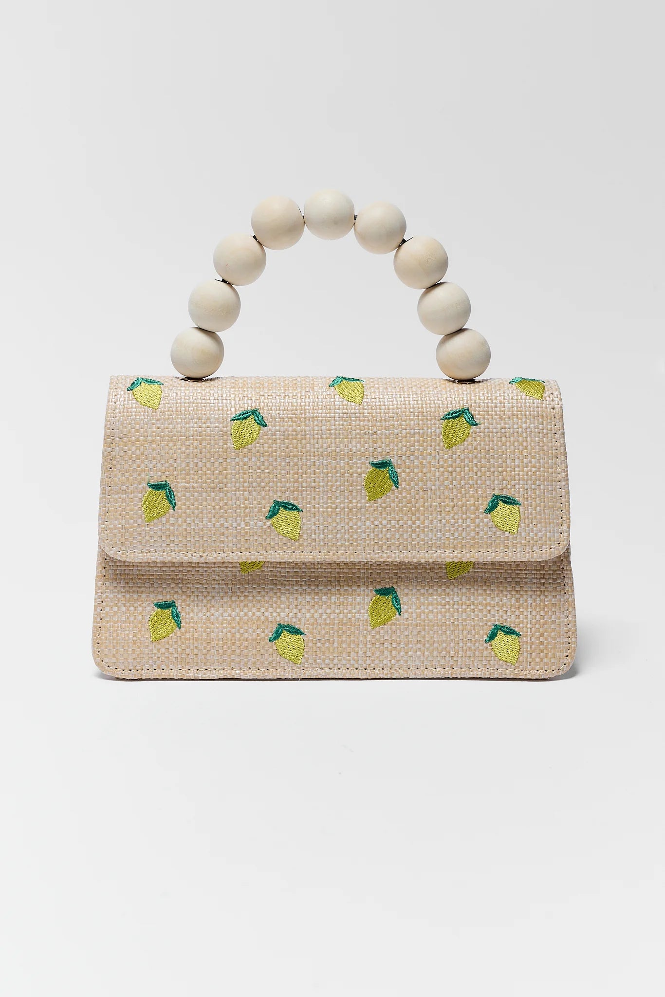 Woven handbag with lemon pattern and wooden handle on a white background