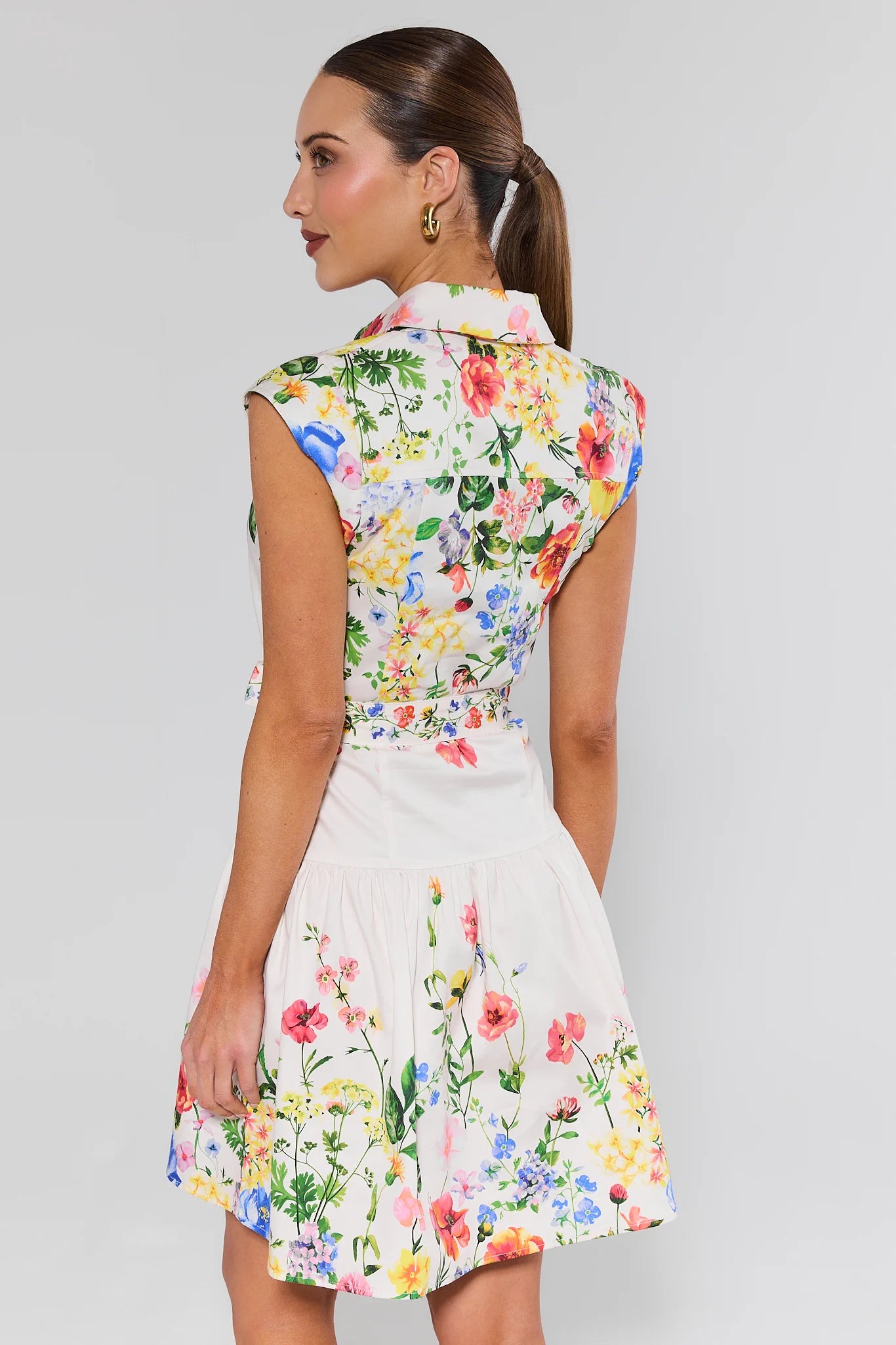 Woman wearing a floral dress against a plain background