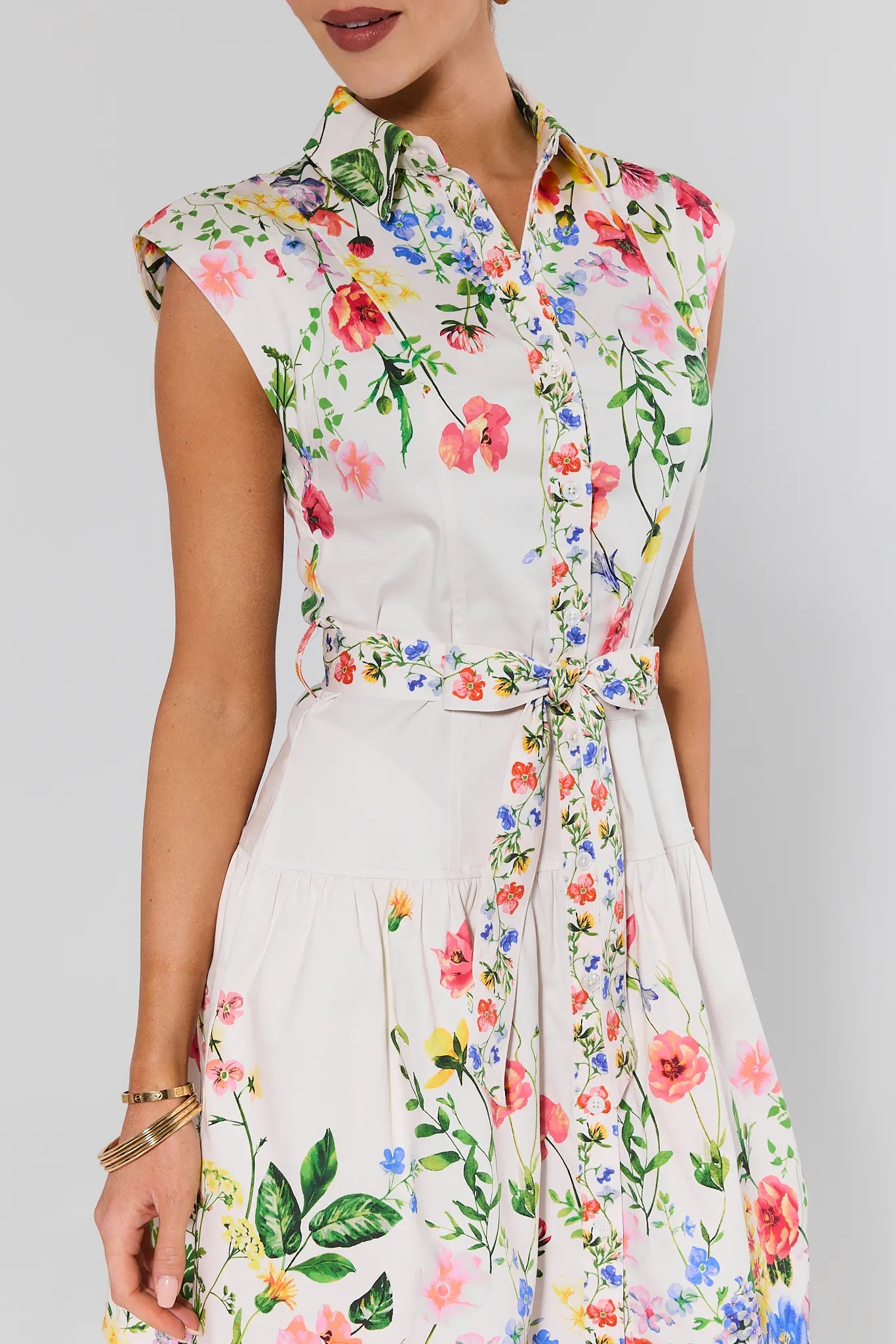 Woman wearing a sleeveless floral dress on a gray background