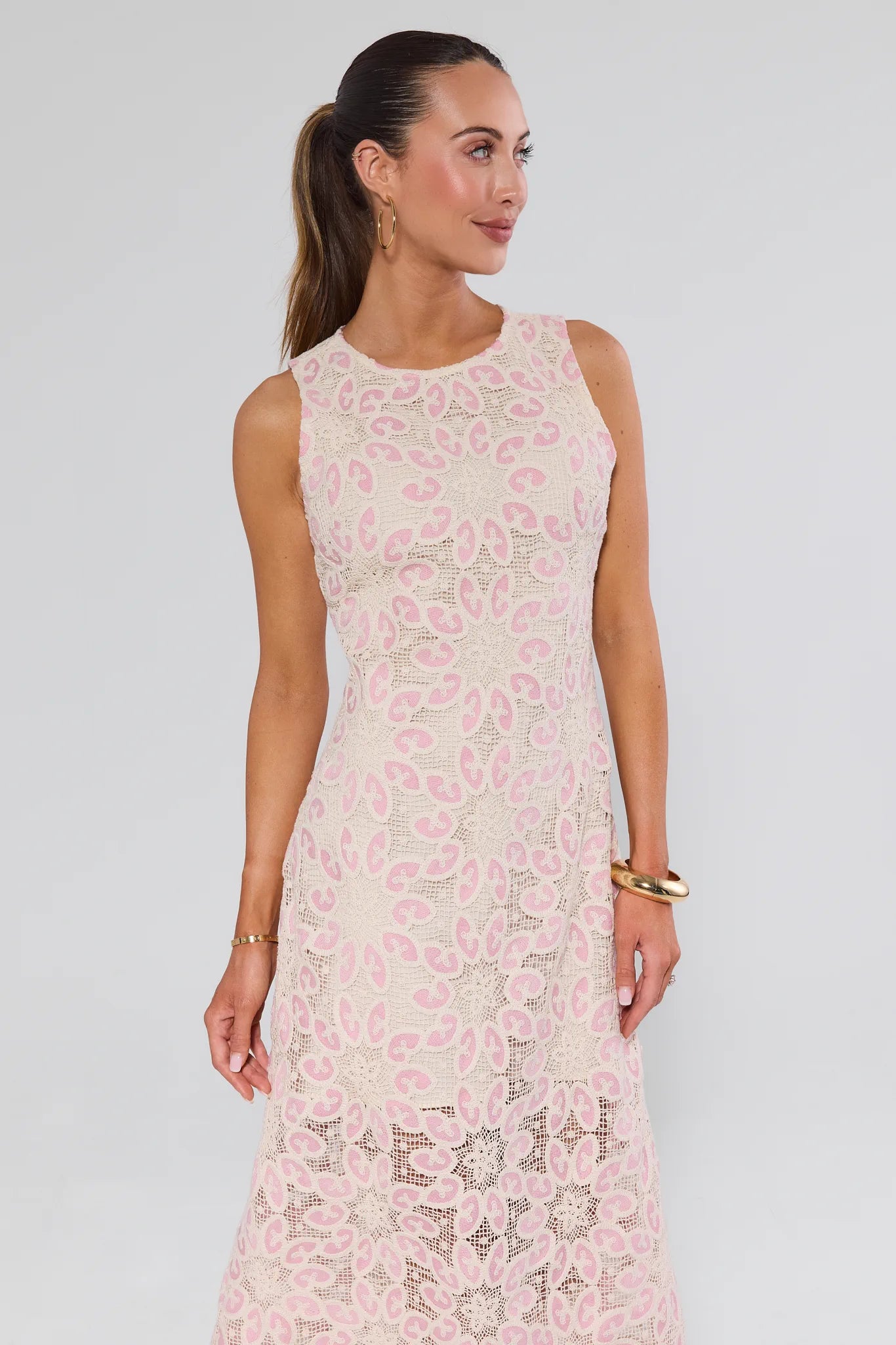 Woman wearing a pink floral dress against a gray background