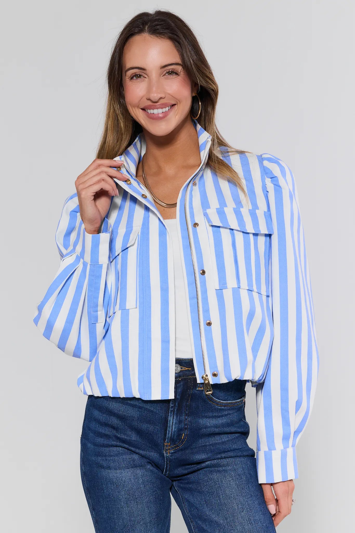 Woman wearing a blue and white striped jacket on a plain background