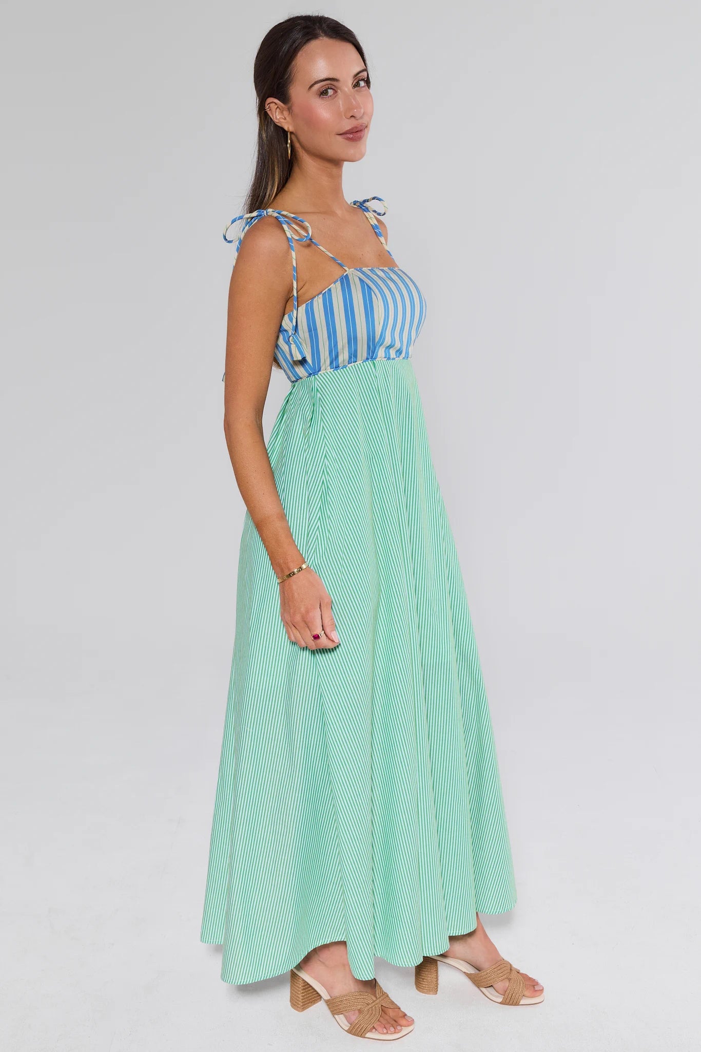 Woman wearing a blue striped top and green skirt on a white background