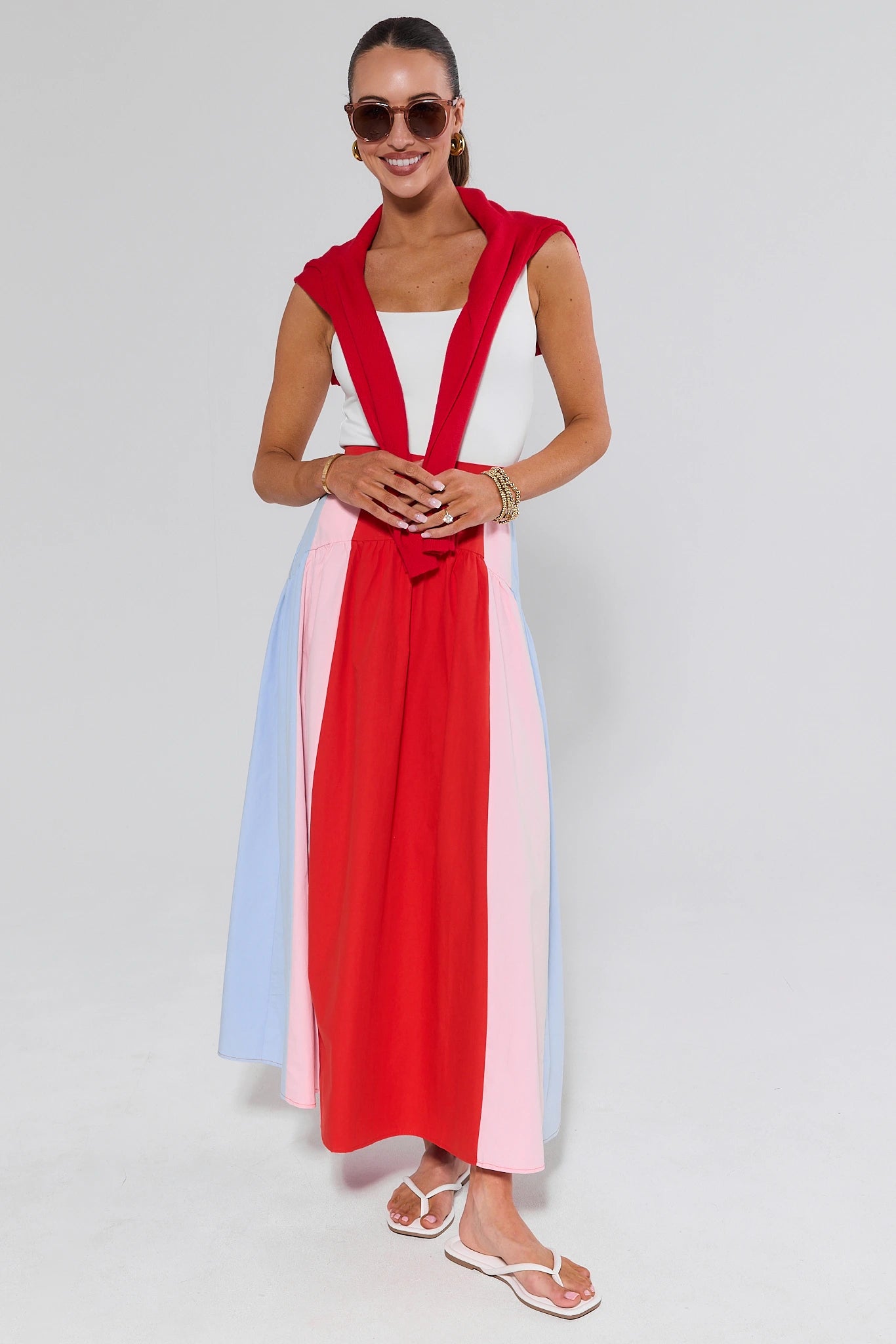 Woman wearing a colorful dress with a red and pink design on a white background