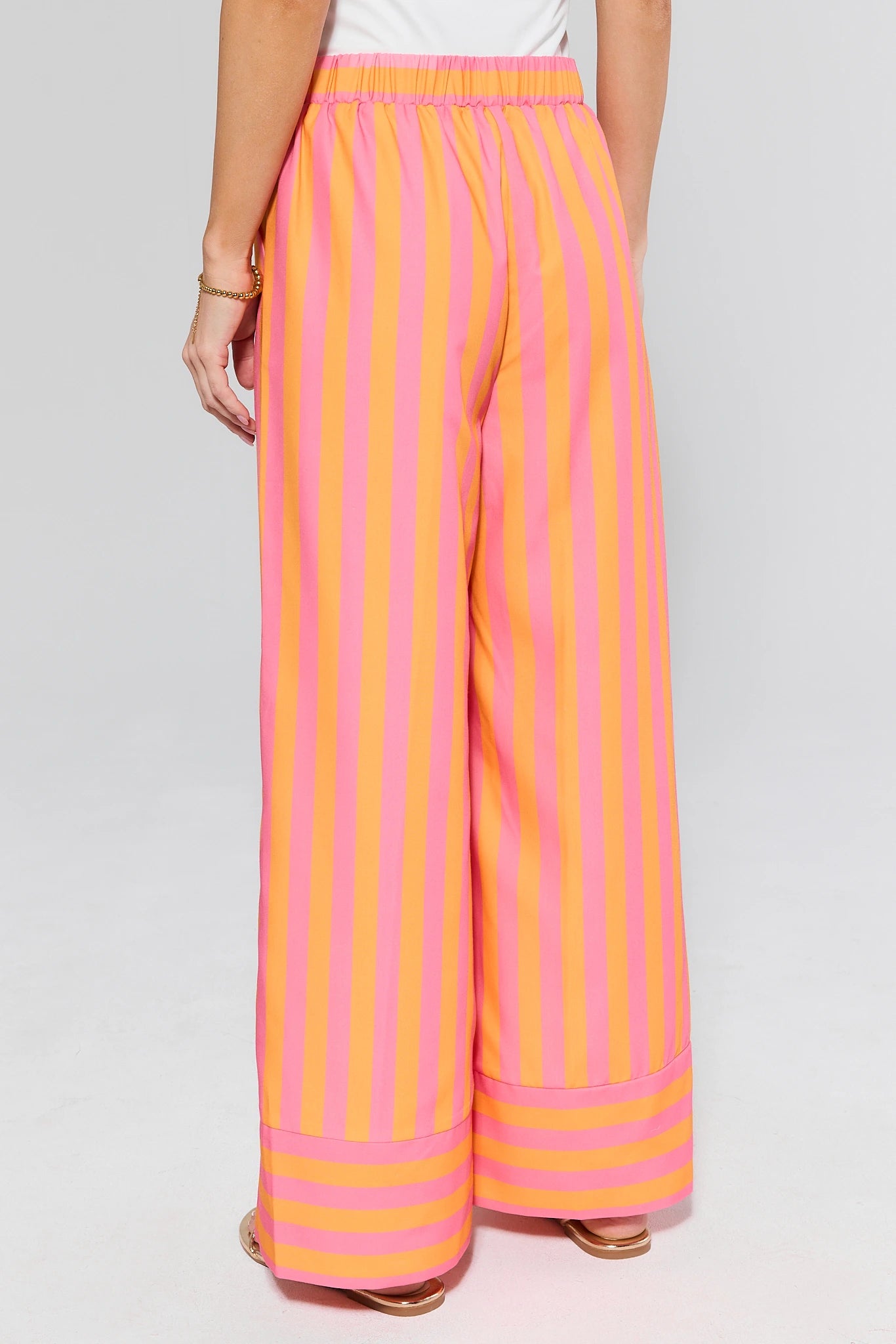 Pink and orange striped pants on a plain background