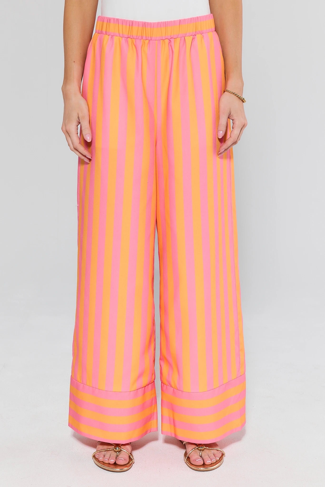 Person wearing pink and orange striped pants on a white background