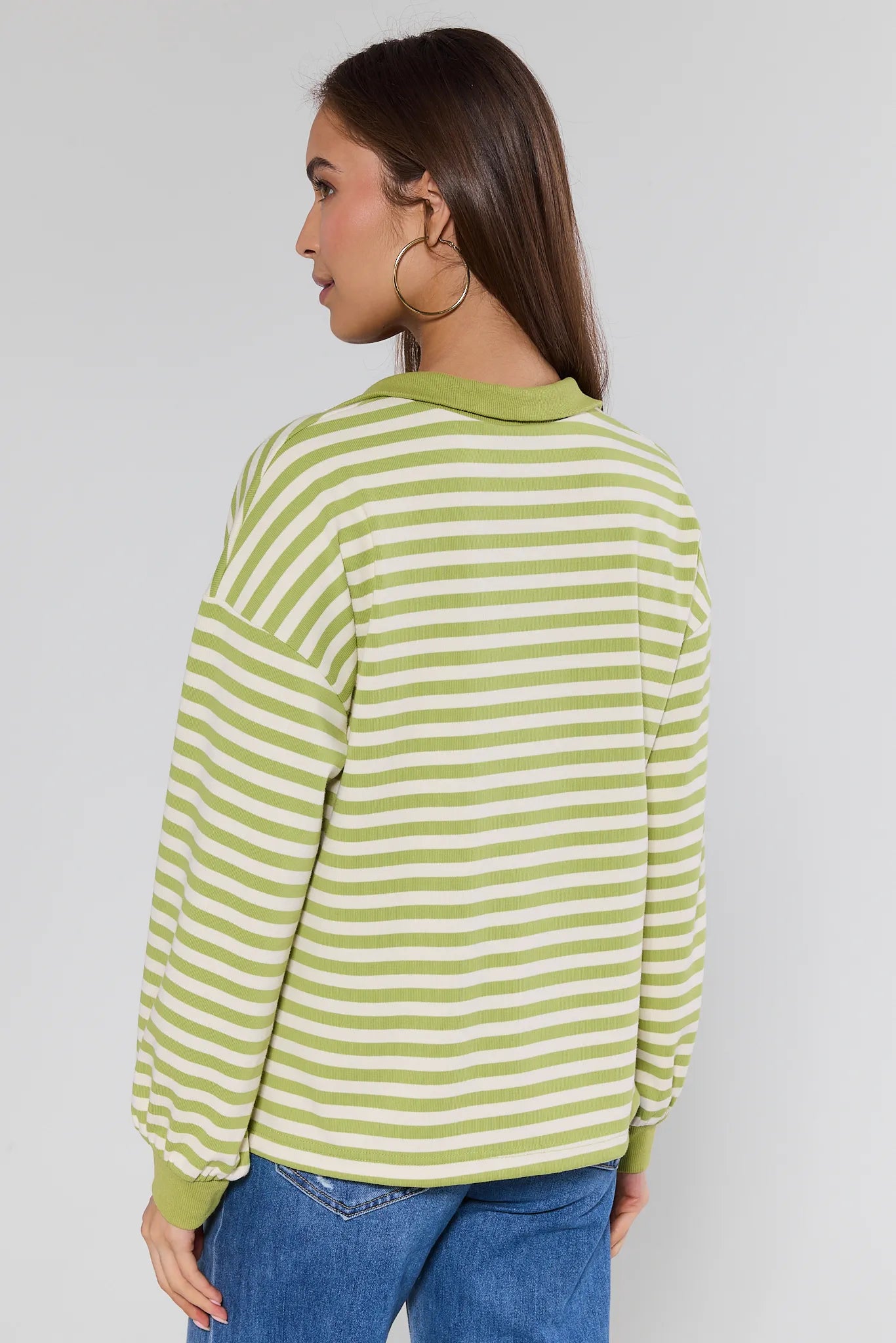 woman wearing green striped sweater on white background