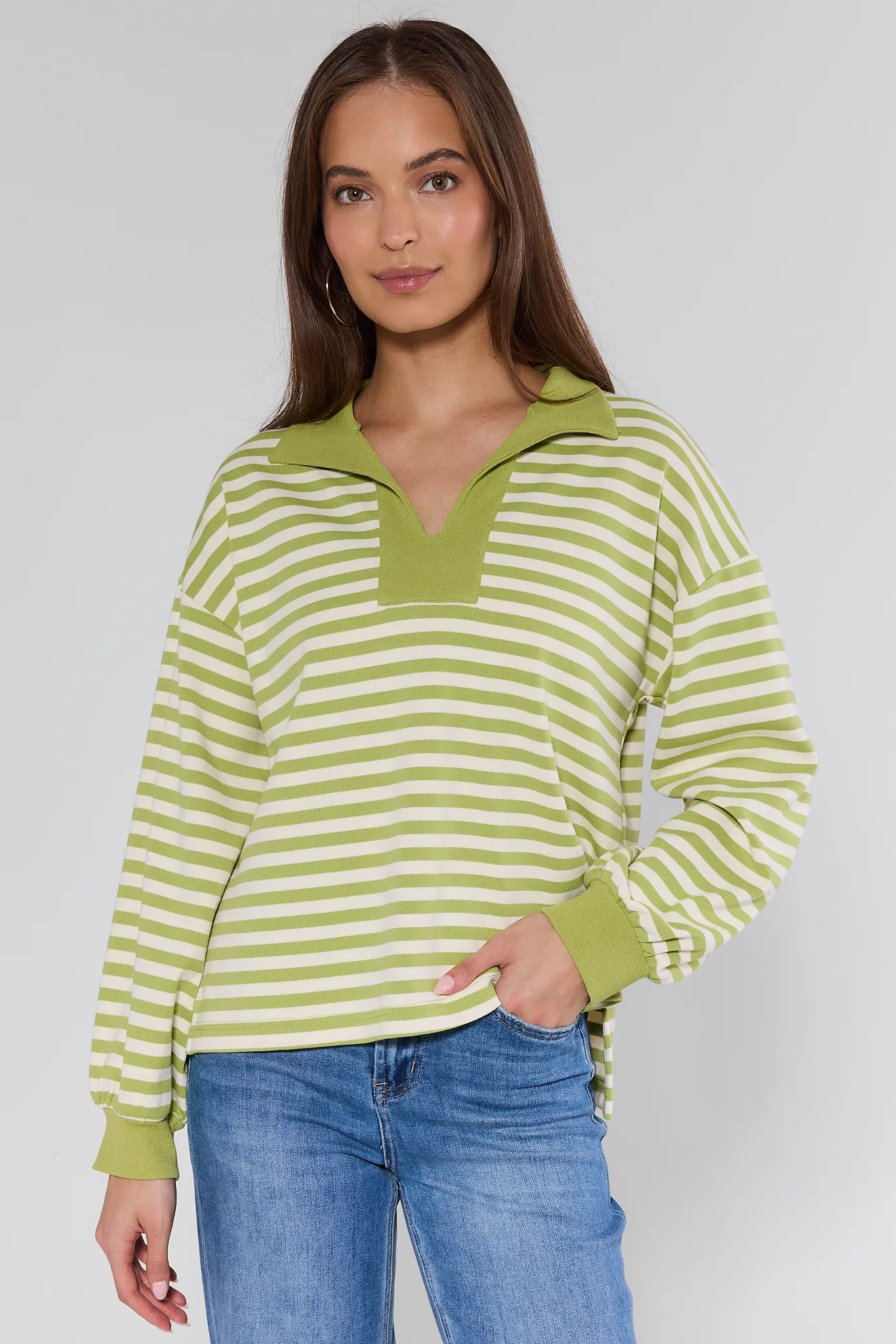 woman wearing green sweater with stripes on white background