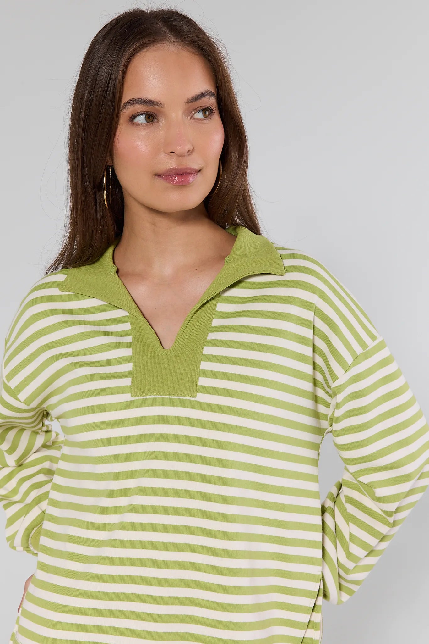 woman wearing green sweater with stripes on white background